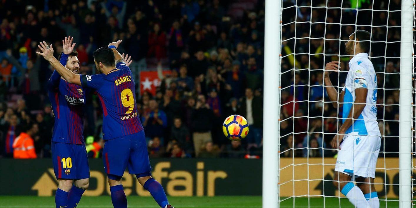 Tvåmålsskytten Luis Suarez kramar om Lionel Messi, vänster, efter 1–0-målet i 4–0-segern mot La Coruna.