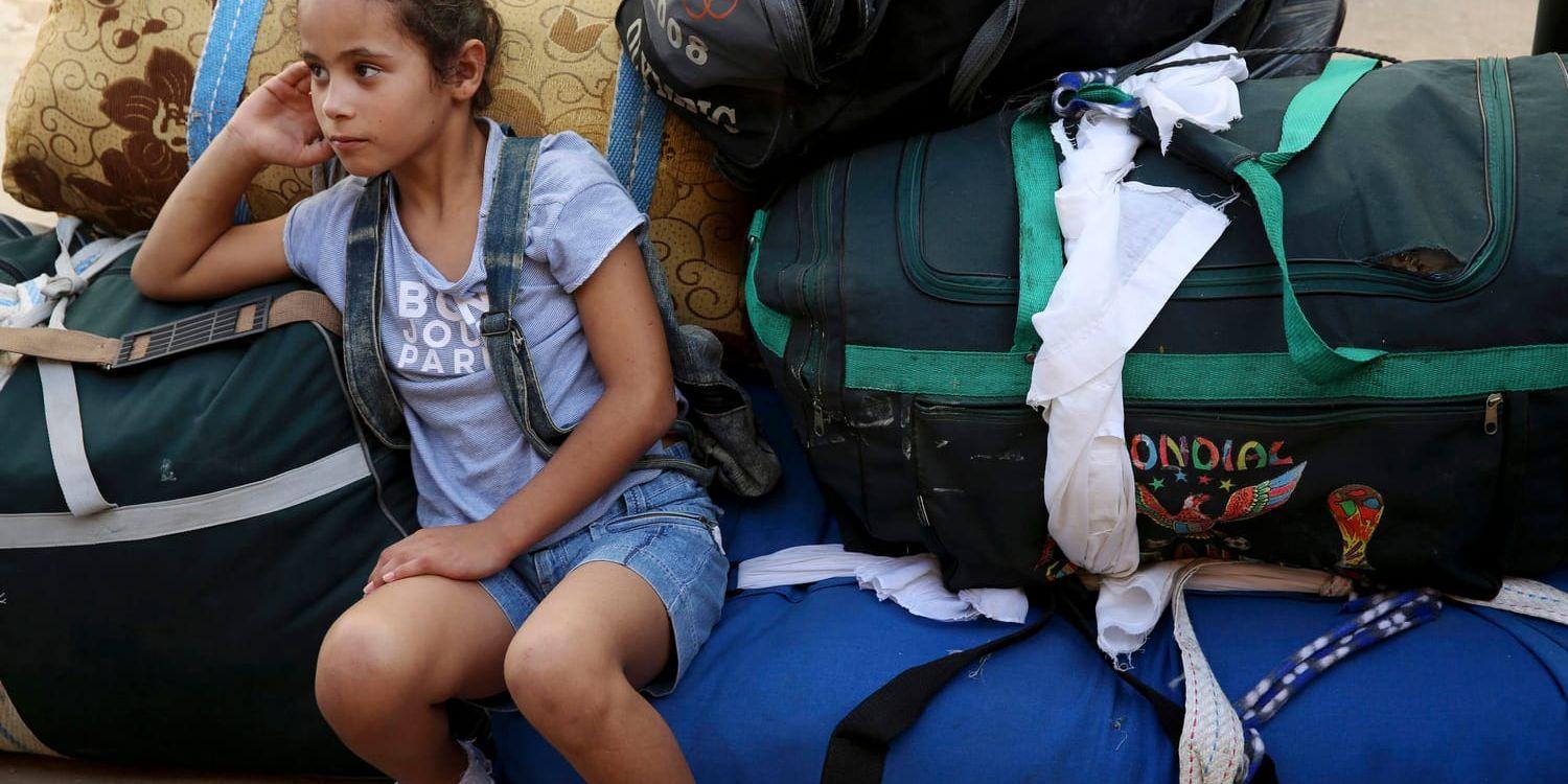 En flicka väntar med familjens bagage på Gaza-sidan av gränsövergången Rafah. Makten över gränsen är en viktig del av försoningssamtalen. Arkivbild.