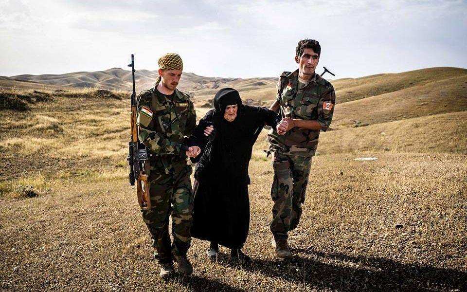 Jesper Söder och en YPG-soldat hjälper en gammal kvinna att fly från IS. Bild: Privat