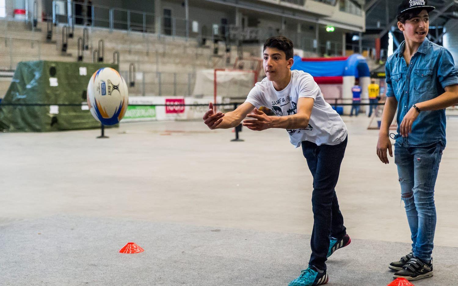 Bild: Christian Flodin. Shuaib Abooun hivar iväg rugbybollen under överseende av Hayman Satar.