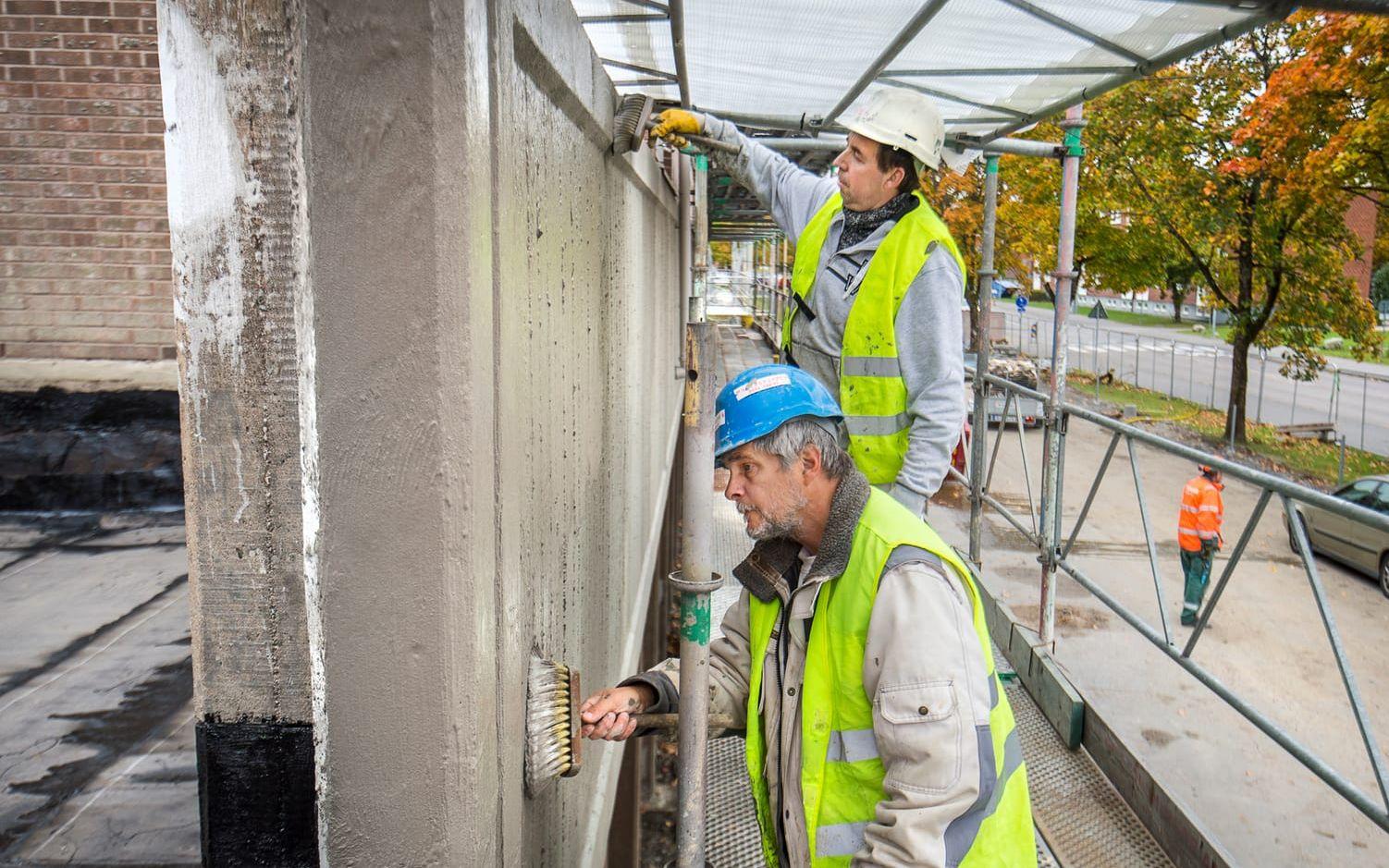 Sten Richardsson, blå hjälm och Sadik Selmenaj, vit hjälm, "slammar på" skydd för betongkonstruktionen.