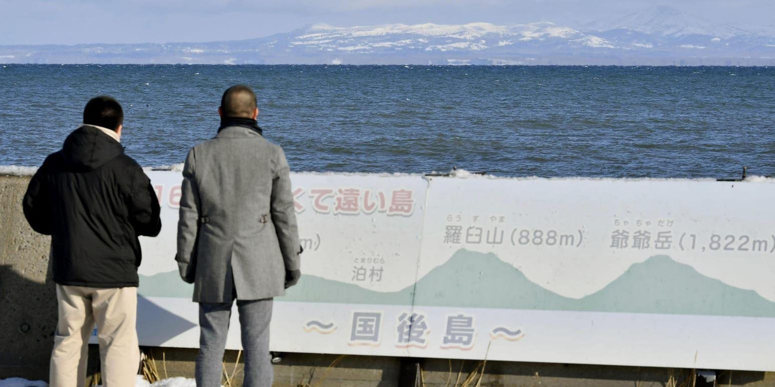 Japanska turister blickar mot ön Kunashiri, en av de ryskkontrollerade öarna i Kurilerna. Arkivbild.