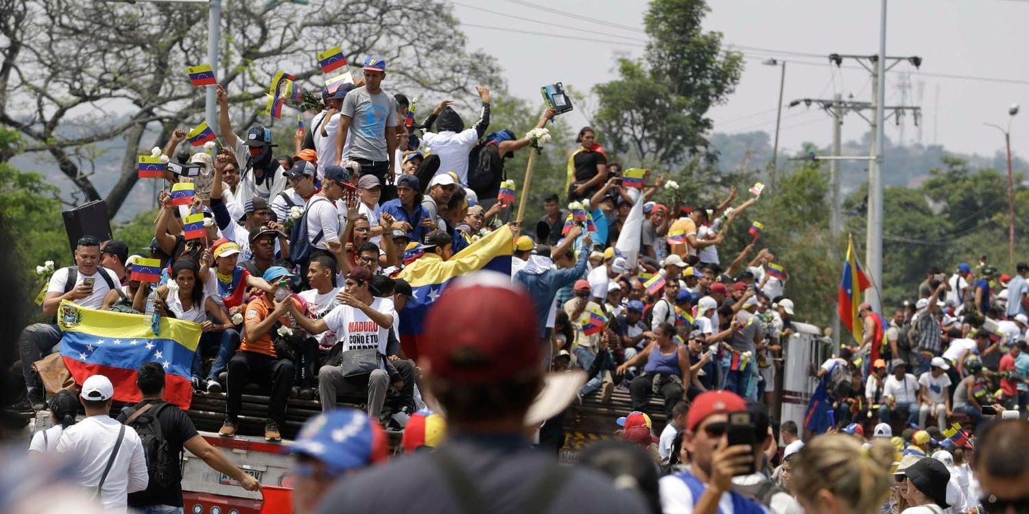 Venezuelaner följer lastbilar med amerikanska hjälpsändningar i colombianska Cúcuta.