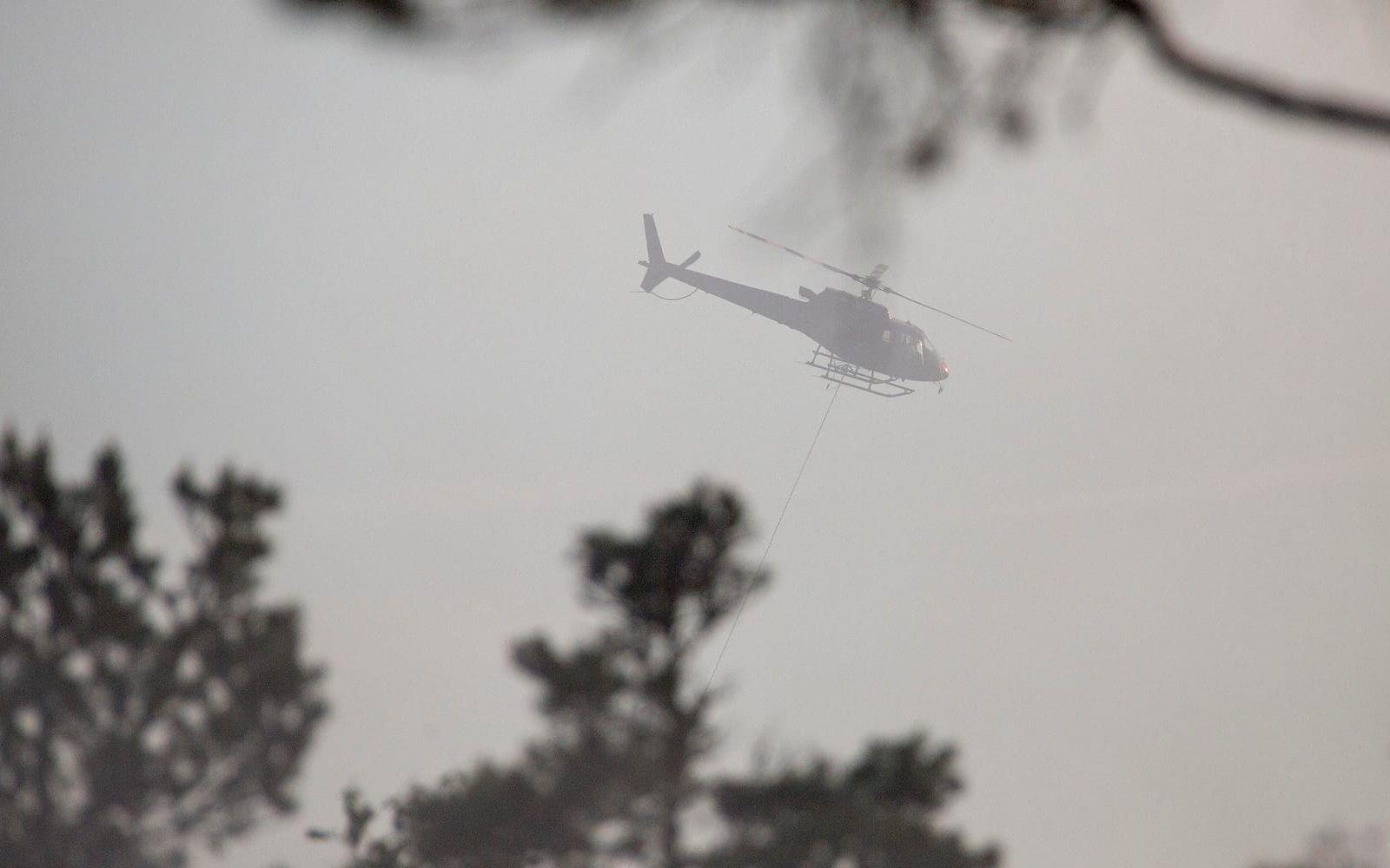 En helikopter har kallats in för att vattenbomba elden från luften. 
