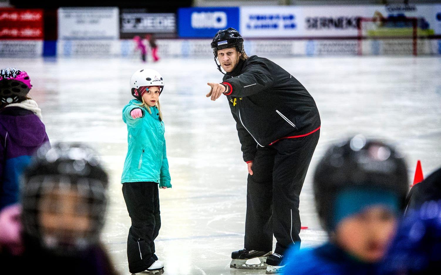 Bild: Stefan Bennhage. Viktor Nordmark, projektledare för Sports On Ice och elitseriespelare i Gripen Trollhättan, pekar ut åkriktningen för Leia Risebrandt.