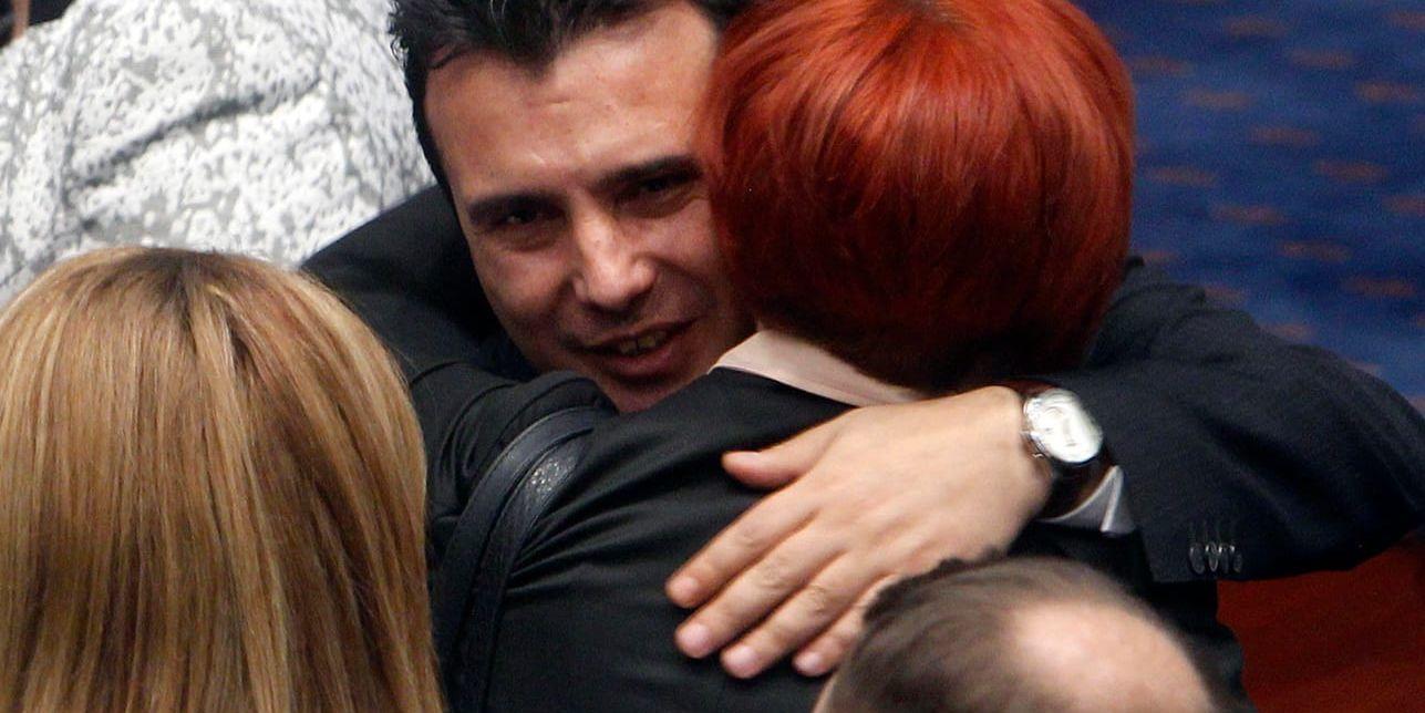 Makedoniens premiärminister Zoran Zaev kramar om parlamentsledamöter efter beslutet om en grundlagsändring.