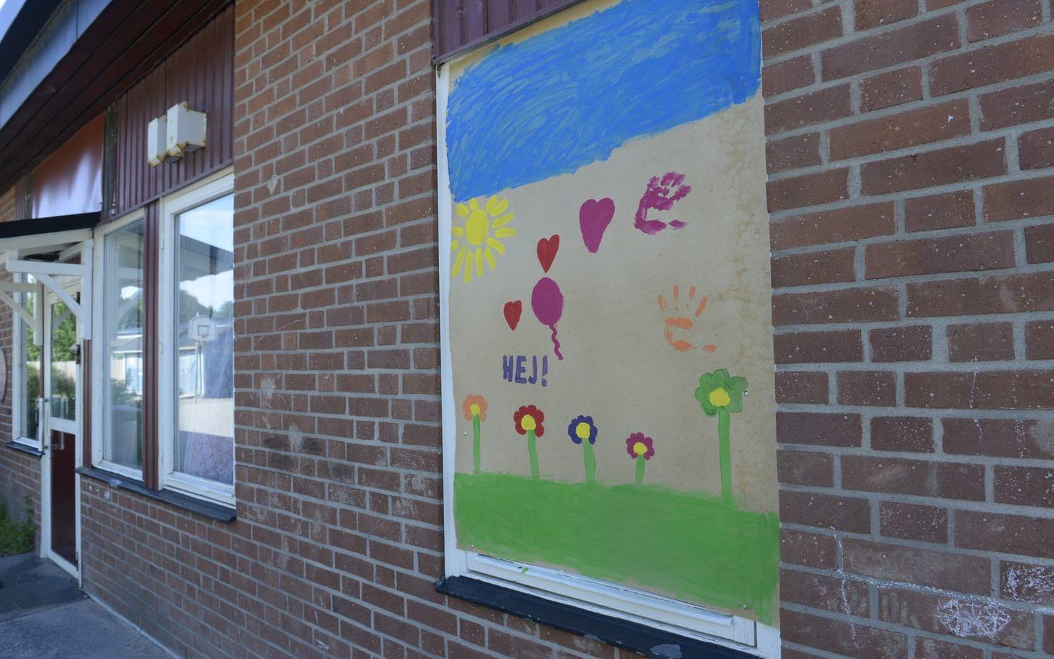 Träskivor täcker de fönster som krossades i Fuxernaskolan, men barnen var snabba med att måla om dem vackert.