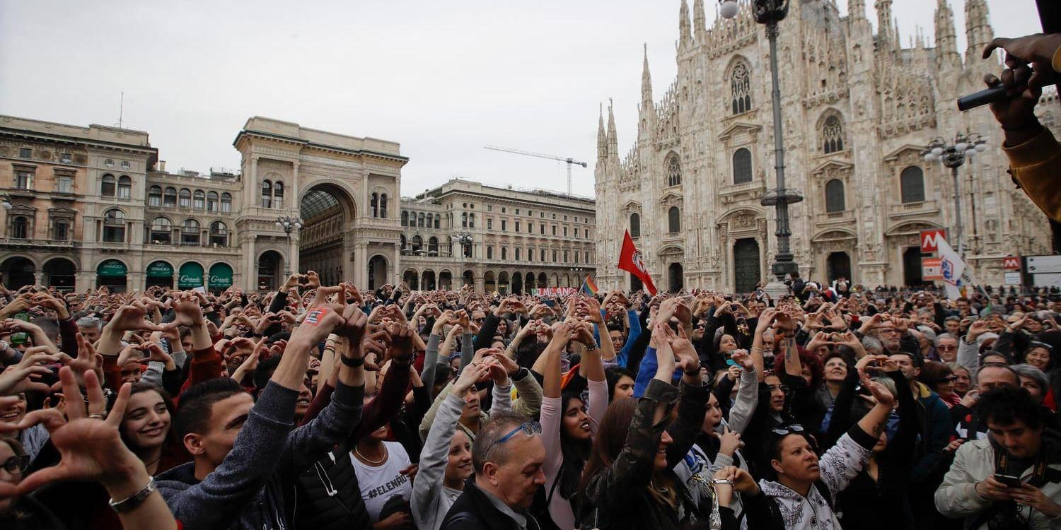 Demonstranter bildar hjärtan med händerna framför den berömda katedralen Duomo di Milano.
