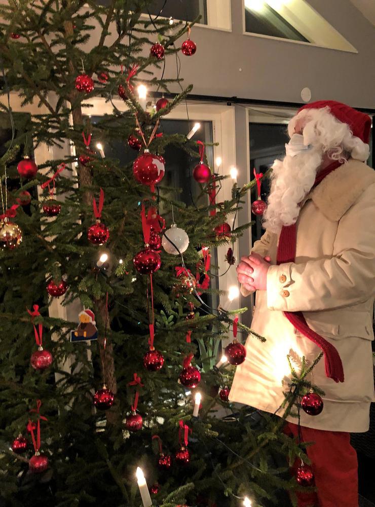 Jultomten, som egentligen kommer från Åsaka och heter Pär Östberg, har både tomtemask och andningsmask men låter hälsa att julen blir god även i år.
