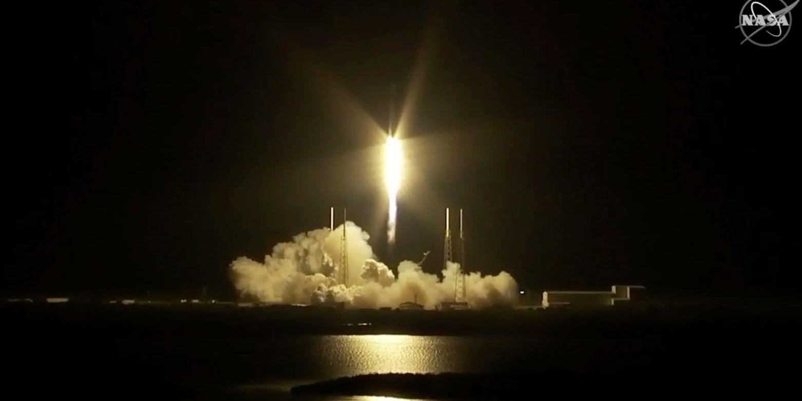 Stillbild från Nasas tv-sändning med Dragon-kapseln som bärs upp av en Falcon-raket från Florida tidigt på lördagsmorgonen amerikansk tid.