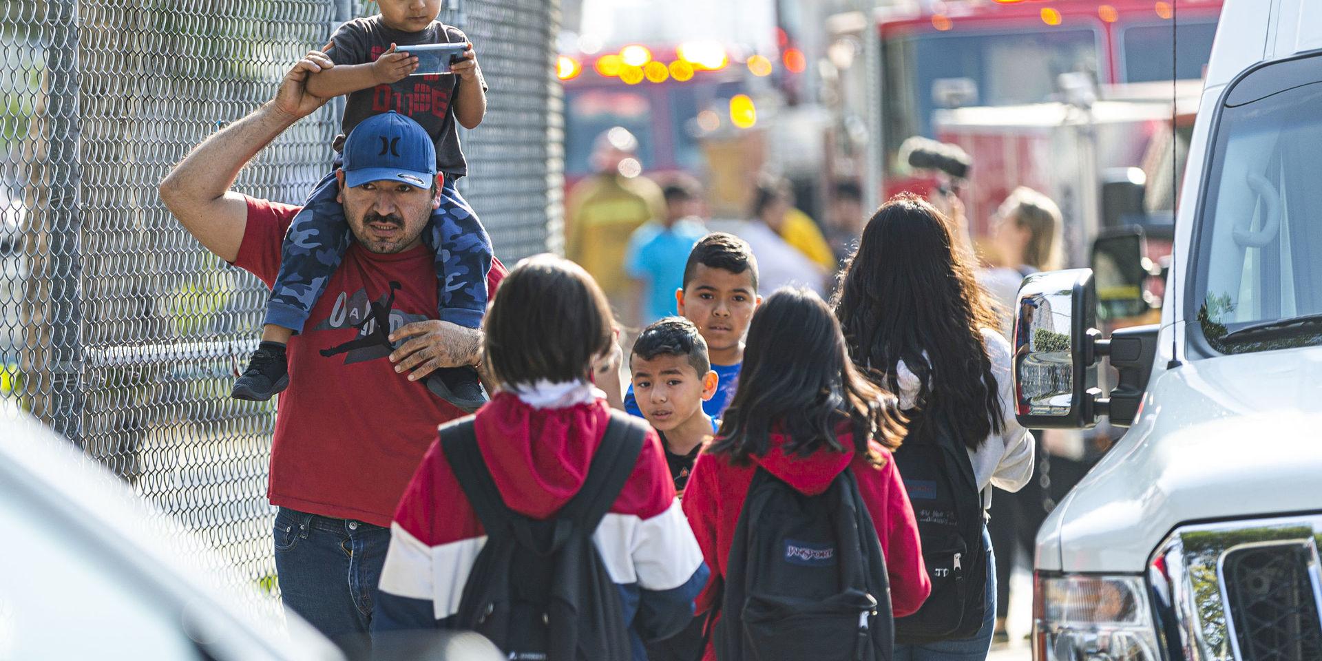Barn evakueras efter att de och deras skola i stadsdelen Cudahy i Los Angeles fått flygbränsle släppt på sig. 