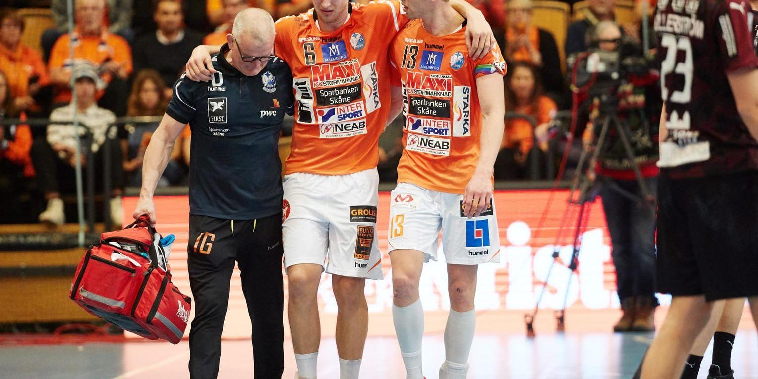 IFK Kristianstads Philip Henningsson, mitten, skadad och hjälps ut av Olafur Gudmundsson och Ingemar Gannby under annandagens match mot Lugi i herrarnas handbollsliga.