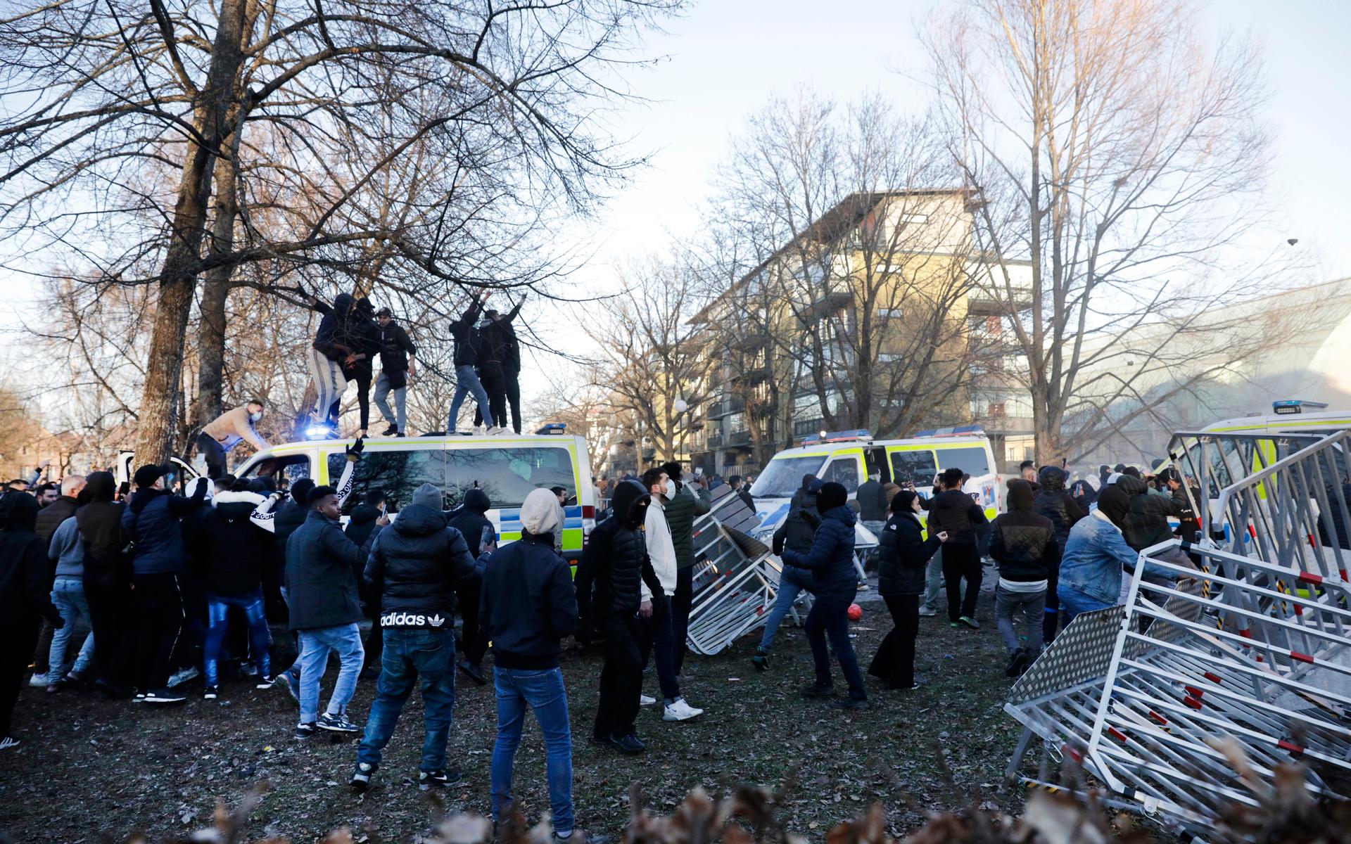 Motdemonstranter klättrar upp på en polisbuss i Sveaparken i Örebro, där Rasmus Paludan, partiledare för det danska högerextrema partiet Stram kurs, har fått tillstånd för en sammankomst på långfredagen. 