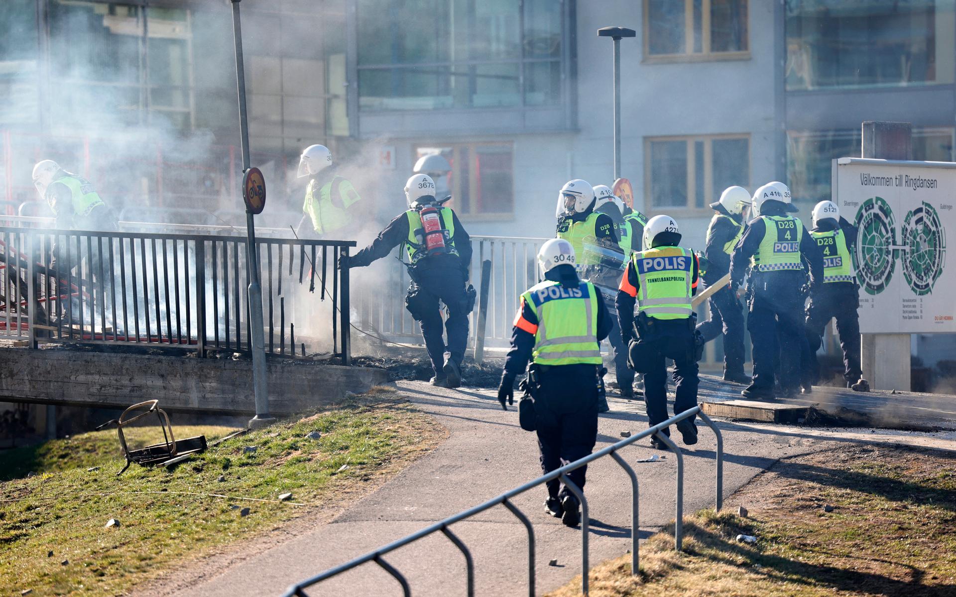 Kravallutrustad polis tar sig förbi en barikad vid Ringdansen centrum under upploppen i Navestad i Norrköping på påskdagen.Oroligheterna utlöstes av att den högerextrema provokatören Rasmus Paludan har sagt att han ska återvända till Östergötland för nya demonstrationer under dagen.