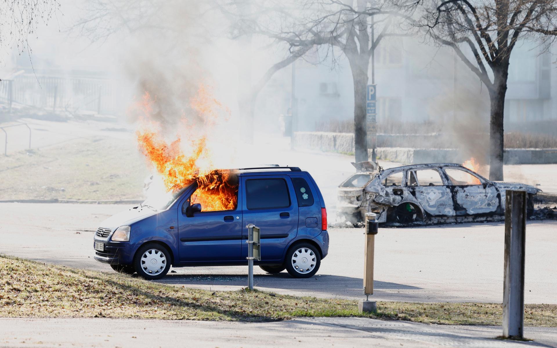 Två bilar brinner på en parkering vid Ringdansen centrum, i samband med upplopp i Navestad i Norrköping på påskdagen.Oroligheterna utlöstes av att den högerextrema provokatören Rasmus Paludan har sagt att han ska återvända till Östergötland för nya demonstrationer under dagen.