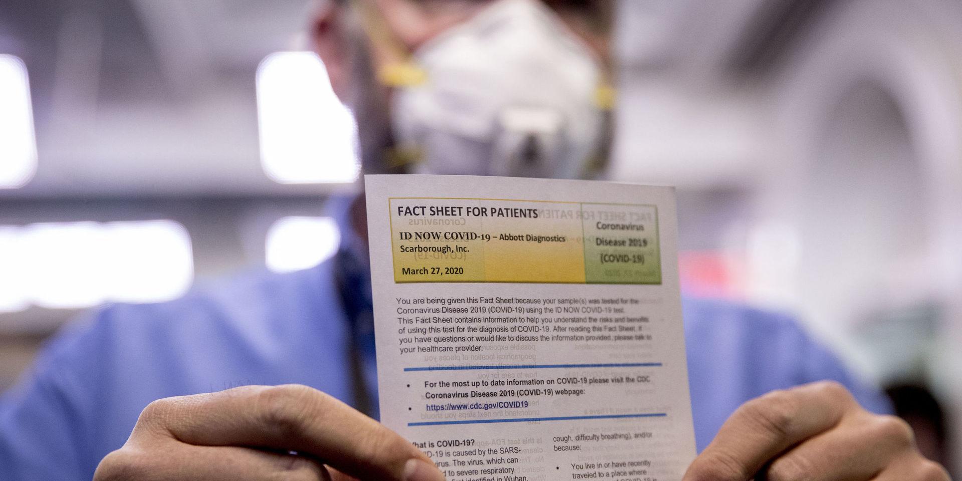 En journalist håller upp ett informationsblad efter att ha genomgått ett snabbtest för coronavirus i Vita huset.