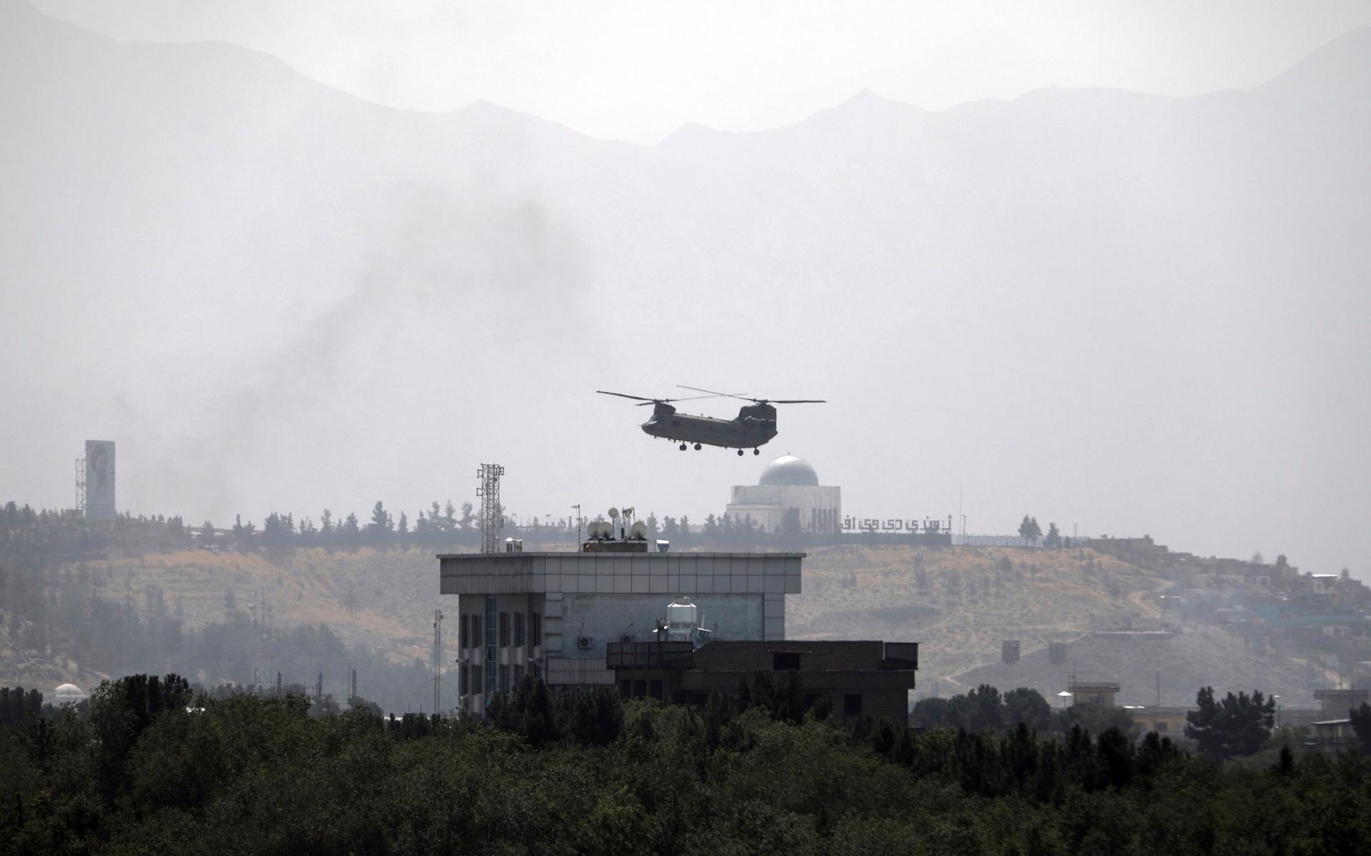 En amerikansk helikopter flyger över amerikanska ambassaden i Kabul på söndagen. Landet evakuerar sina medarbetare i Afghanistan. 