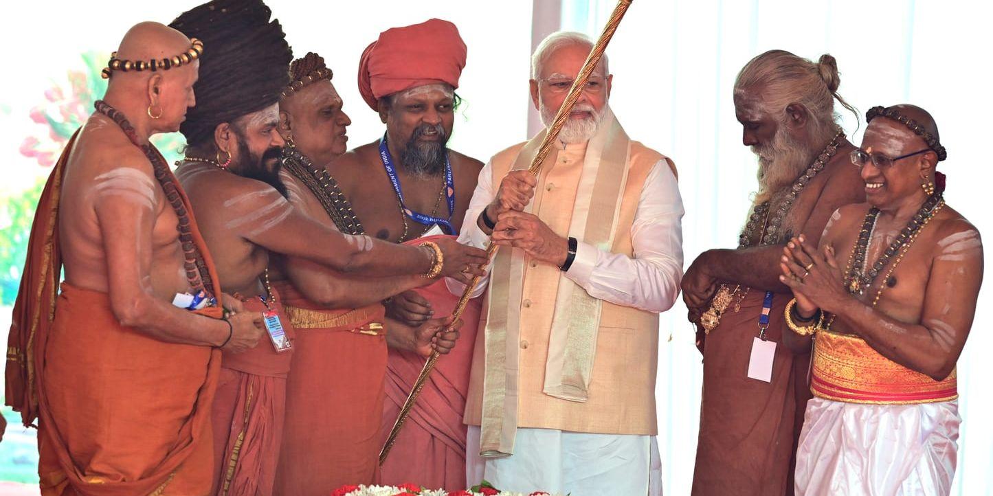 En gyllene spira ska, enligt Modi och BJP, symbolisera maktöverföringen i Indien. I ceremonin bar Modi fram och installerade den vid talarstolen, flankerad av hinduiska präster.