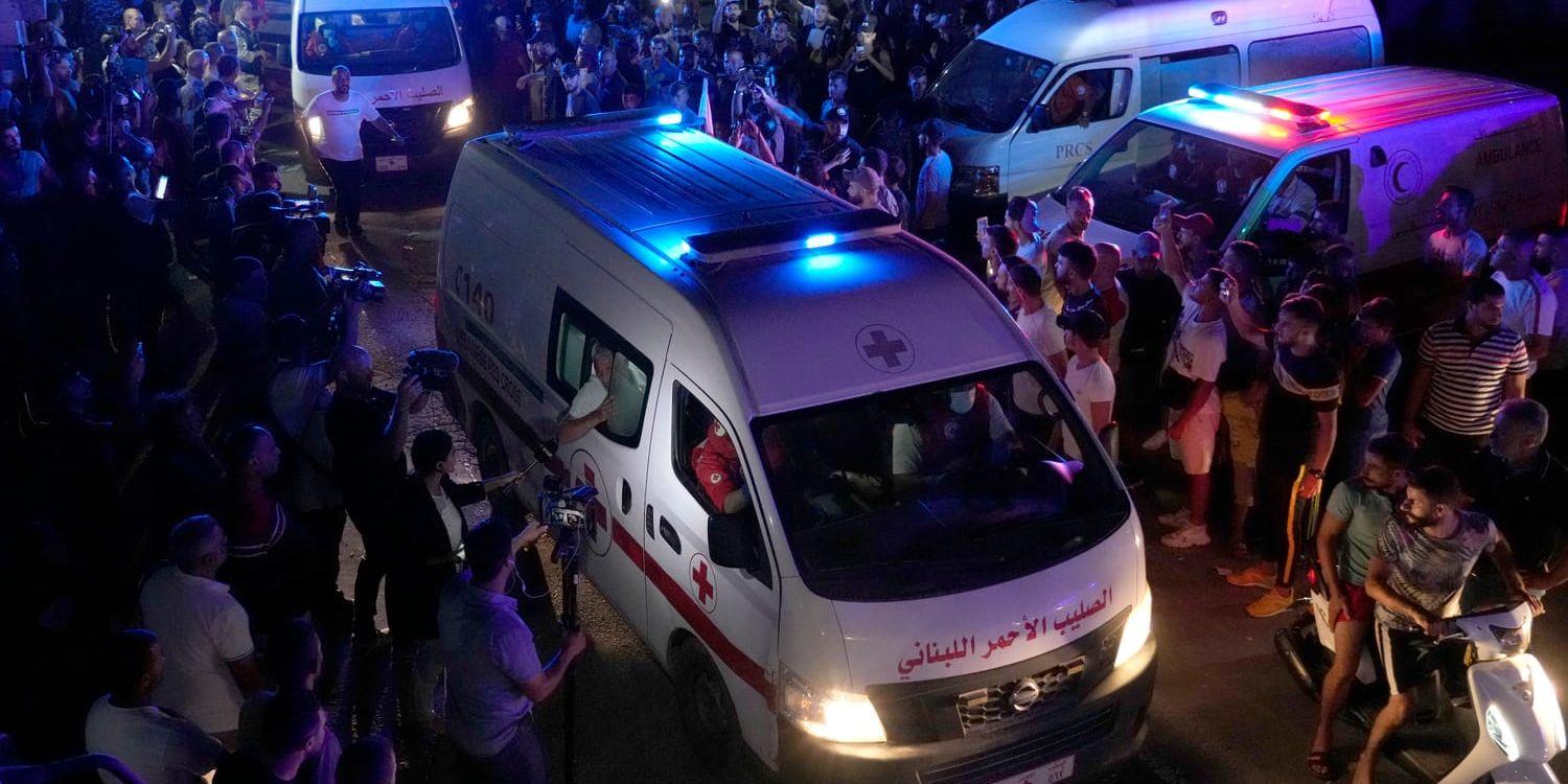 Ambulanser från libanesiska Röda korset transporterar avlidna som drunknade över gränsen, från Syrien till Libanon, på fredagen.