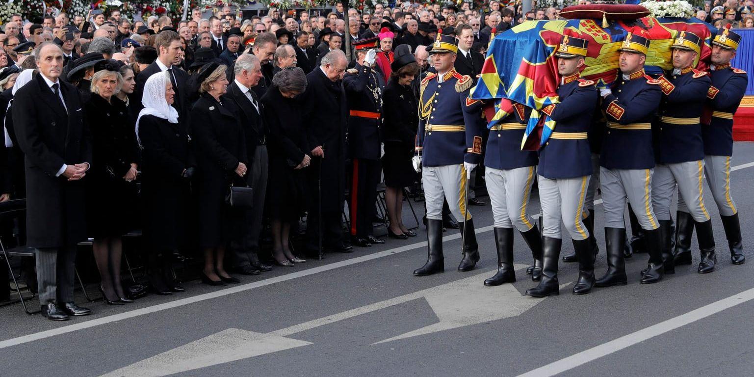 Mikaels kista bärs längs Bukarests gator. Sveriges drottning Silvia syns i mitten av bilden, närmast till vänster om de bärande hedersvakterna.