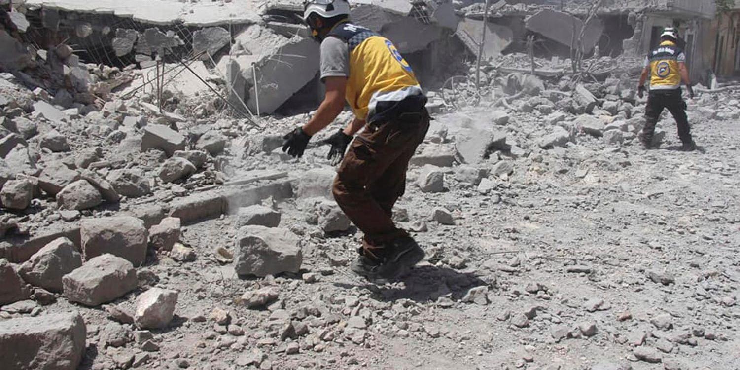 En bild tagen av civilförsvaret Vita hjälmarna, och vars äkthet har verifierats av nyhetsbyrån AP, visar räddningsarbetare i rasmassor efter ett flyganfall i södra Idlibprovinsen den 1 juni.