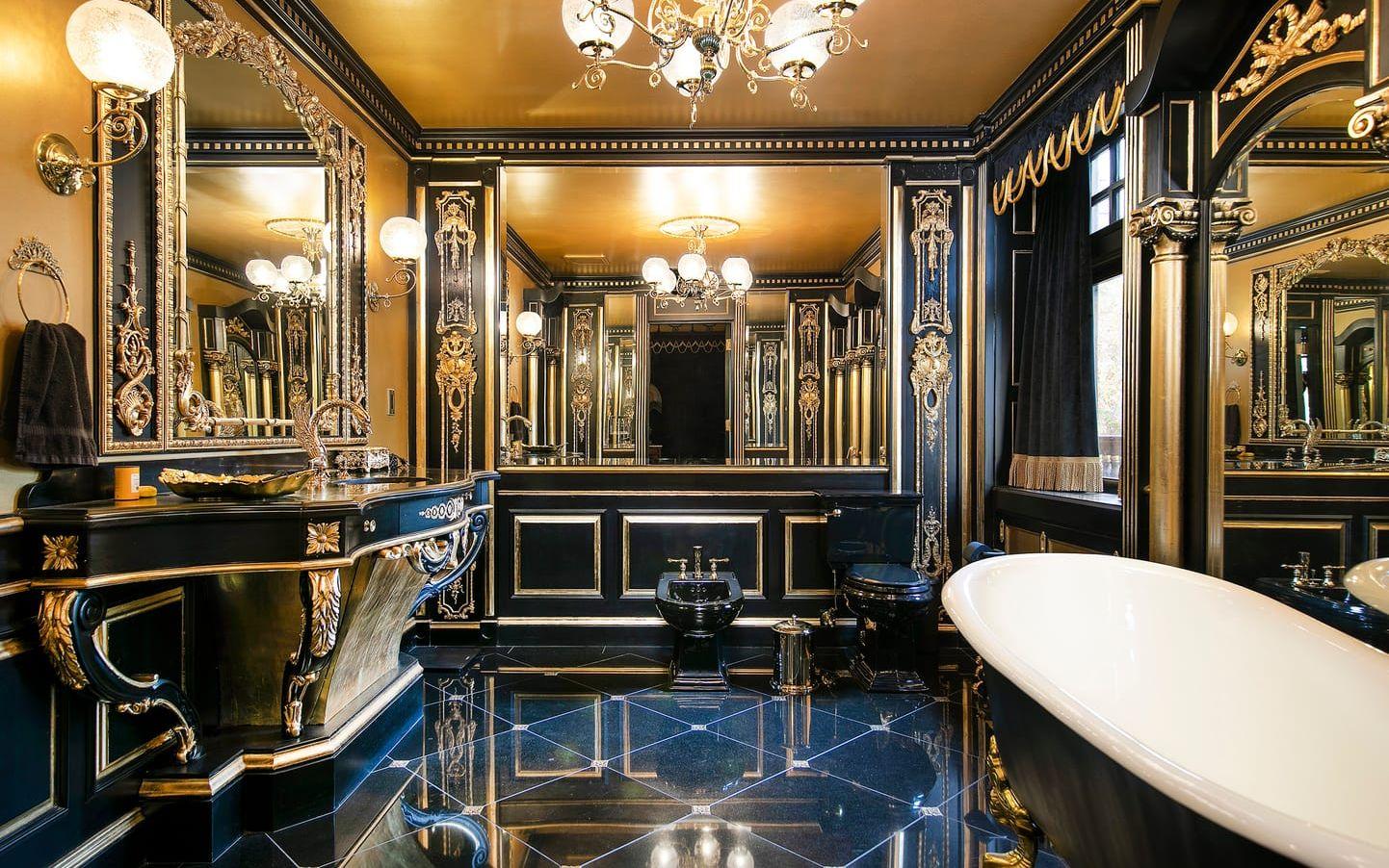 I det här badrummet har man satsat på svart porslin och mycket gulddetaljer. Tvättställskranen ser ut som en drake. Udda.