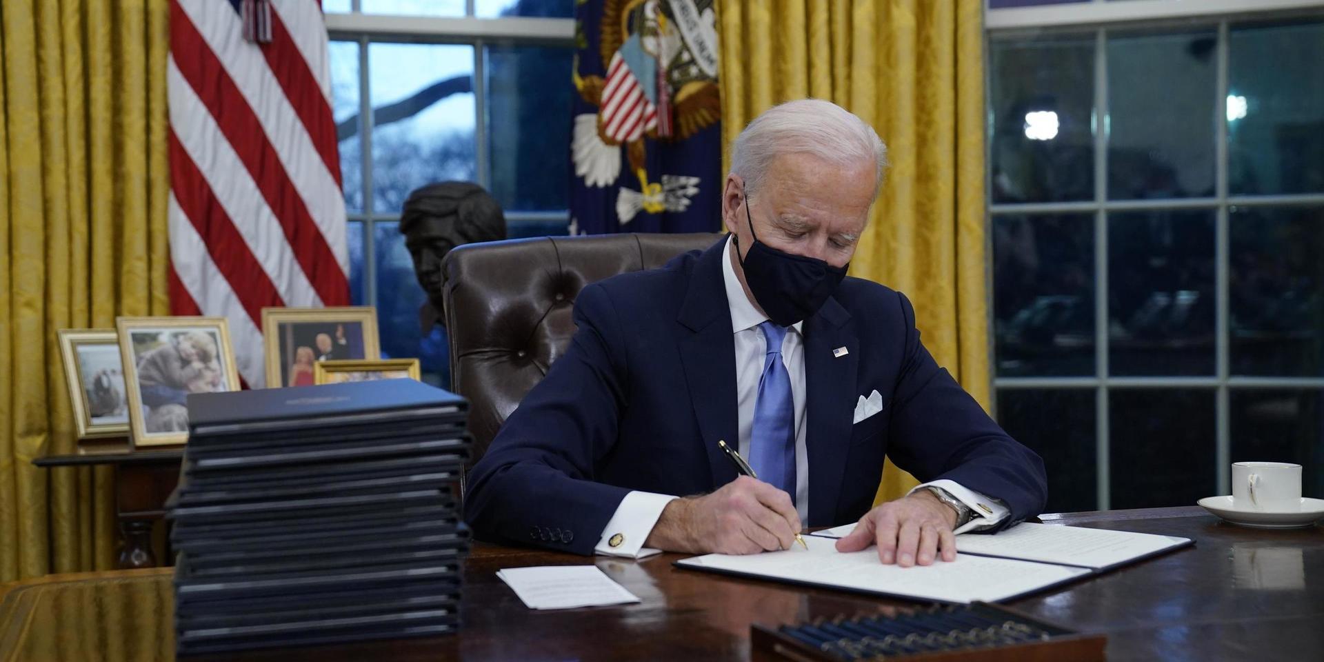 USA:s nye president Joe Biden undertecknar presidentordrar i Ovala rummet.