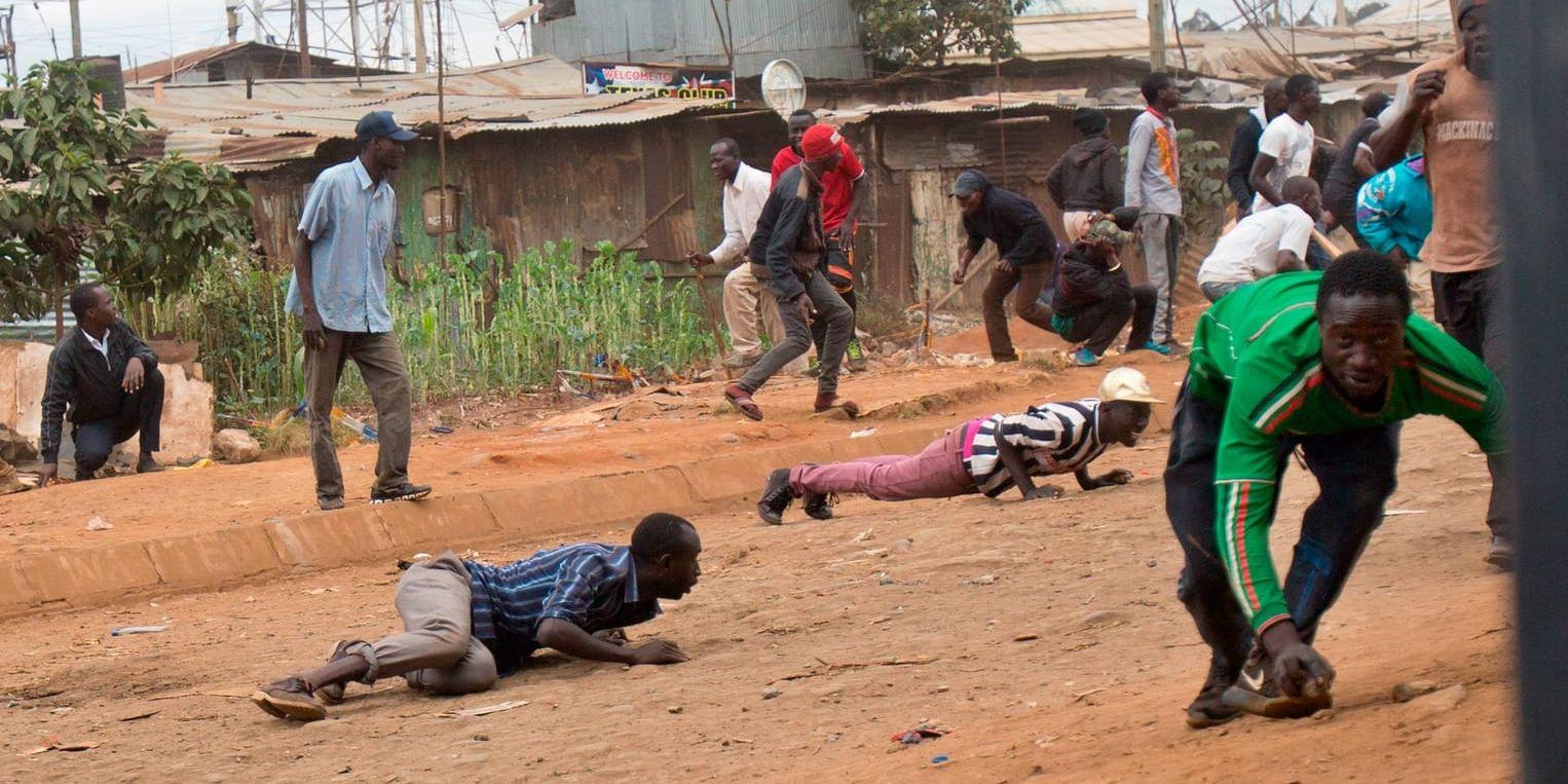 Anhängare till Kenyas oppositionsledare Raila Odinga duckar för polisens kulor i slumområdet Kibera i huvudstaden Nairobi.