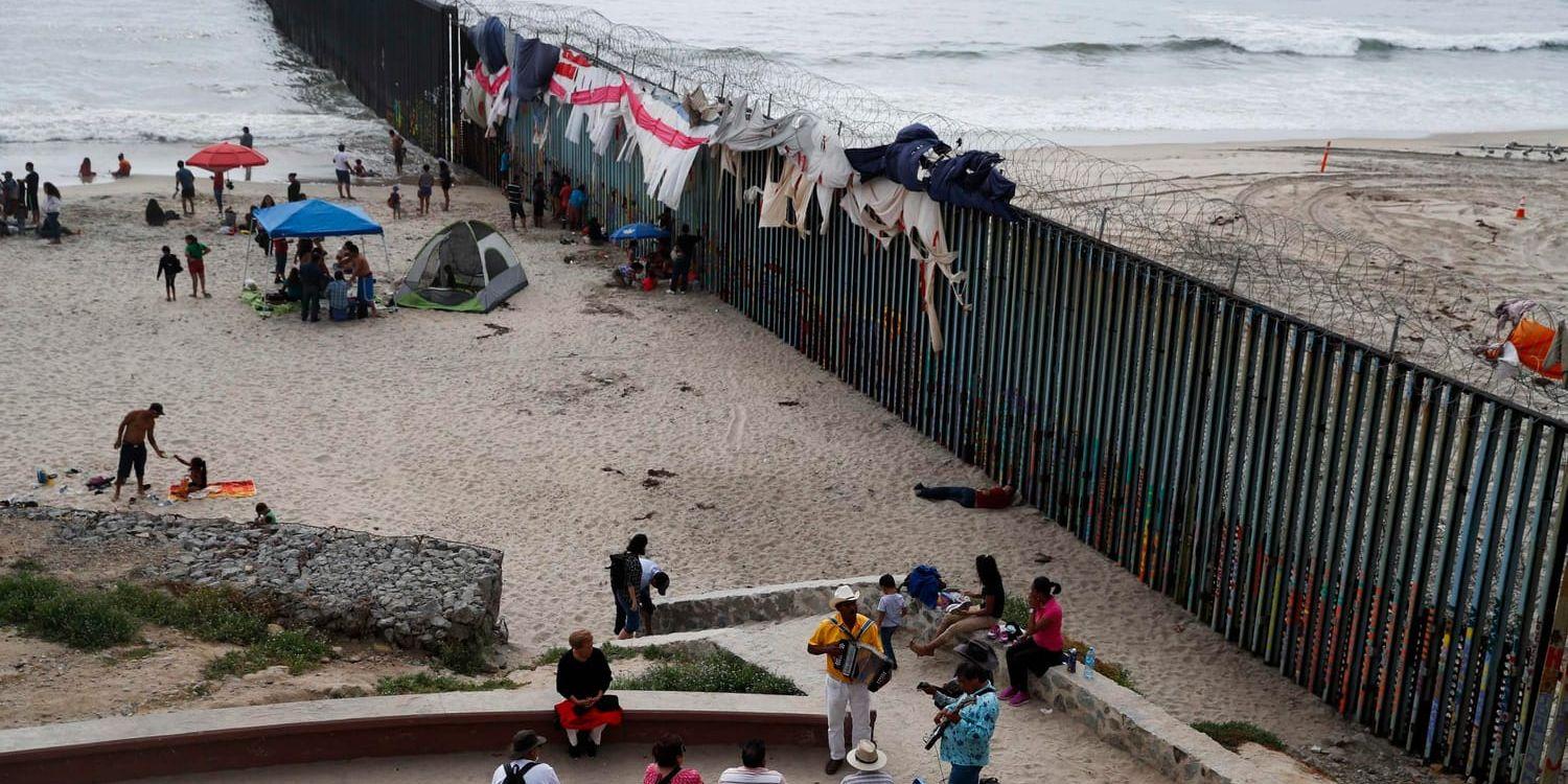 Musiker spelar på stranden intill den taggtrådsförsedda gränsmuren i Tijuana, Mexiko. Arkivbild.