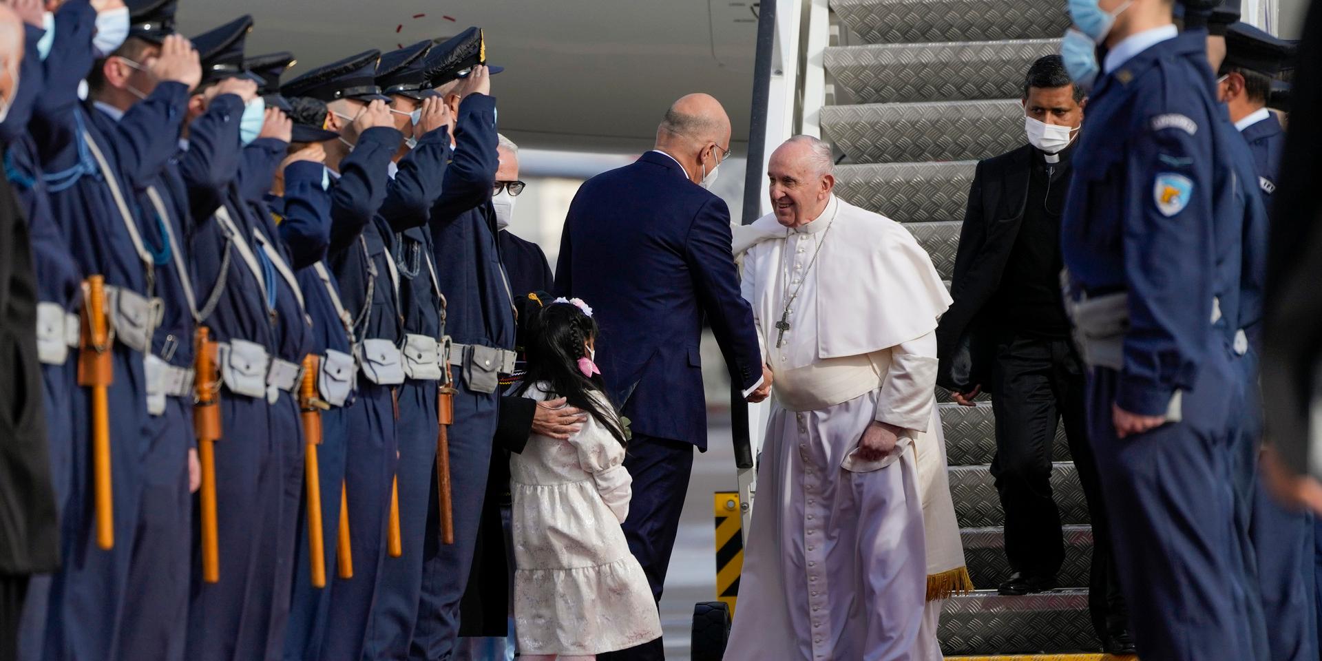 Påve Franciskus tas emot av Greklands utrikesminister Nikos Dendias i Aten.