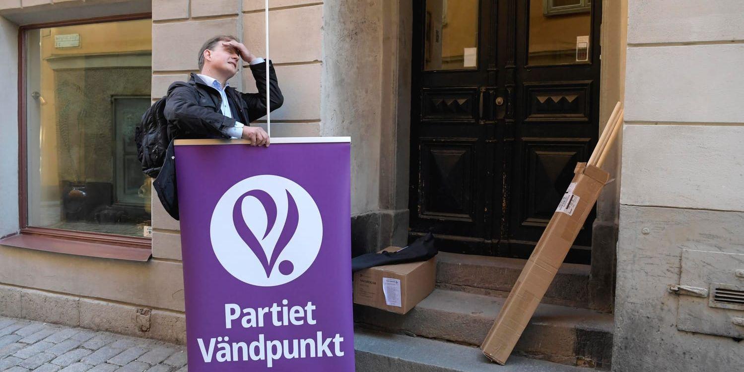 Partiet Vändpunkts talesperson Carl Schlyter sätter upp en partiaffisch utanför partikansliet i Gamla stan i Stockholm.