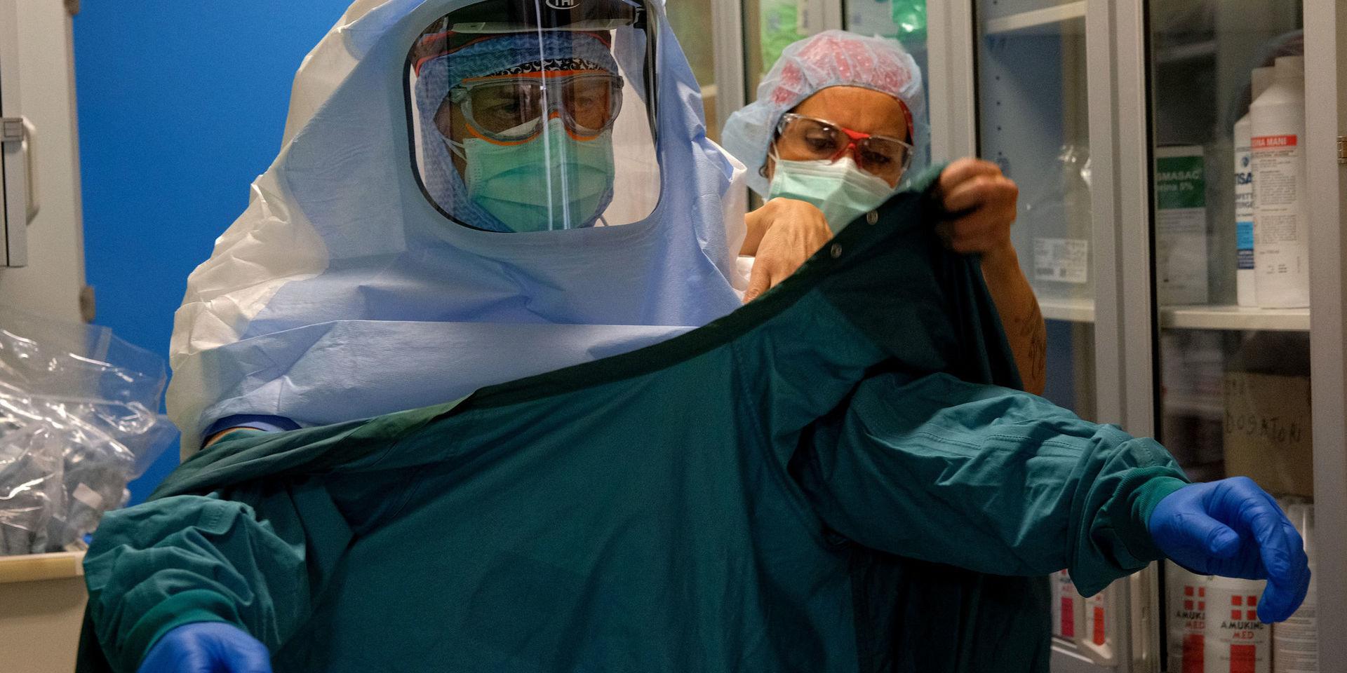 En sjuksköterska hjälper en kollega att sätta på sig skyddsutrustning vid en covid-19-avdelning i Rom i mitten av april. 