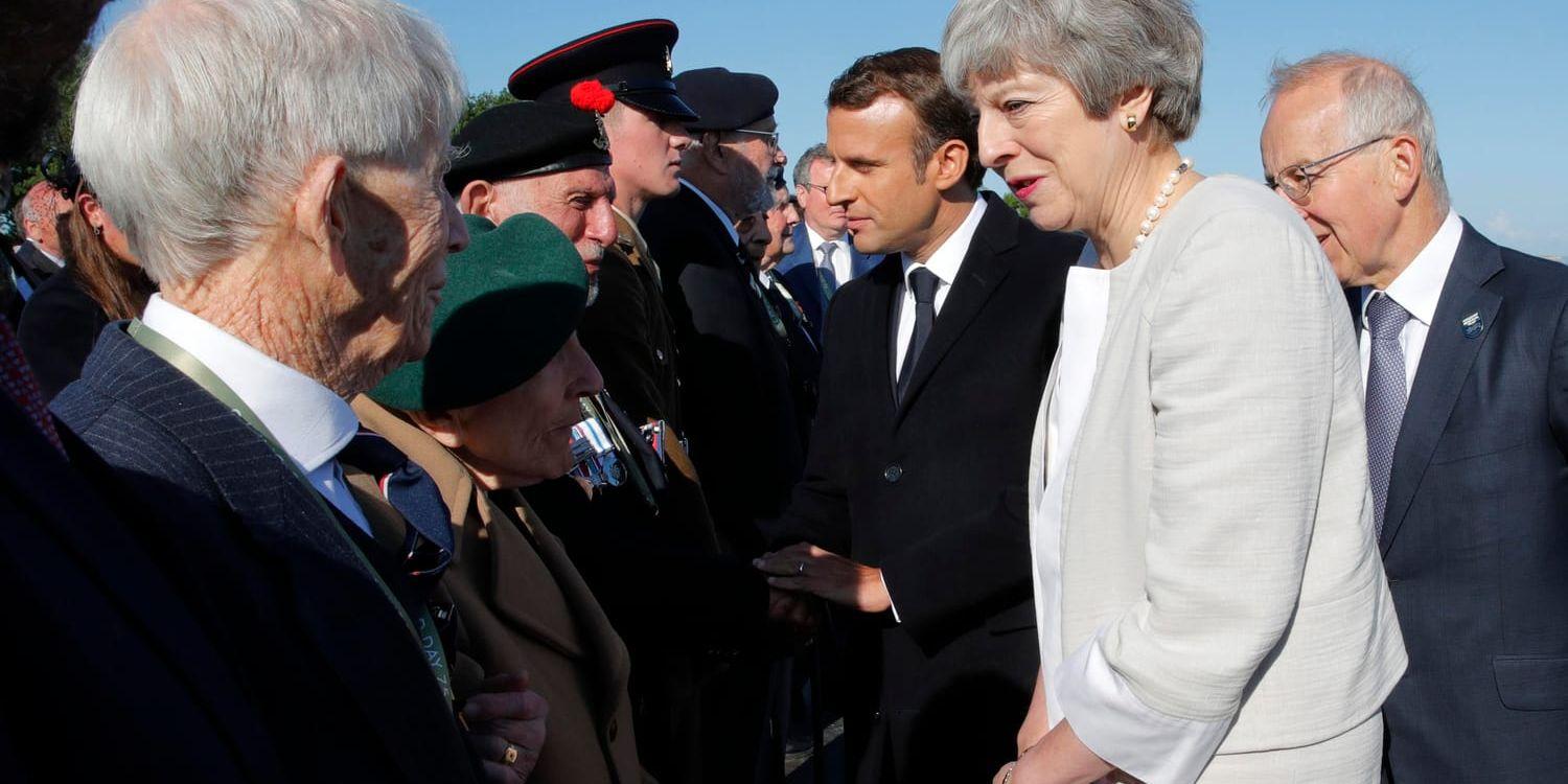 Storbritanniens premiärminister Theresa May och Frankrikes president Emmanuel Macron hälsar på veteraner som var med under D-dagen den 6 juni 1944.