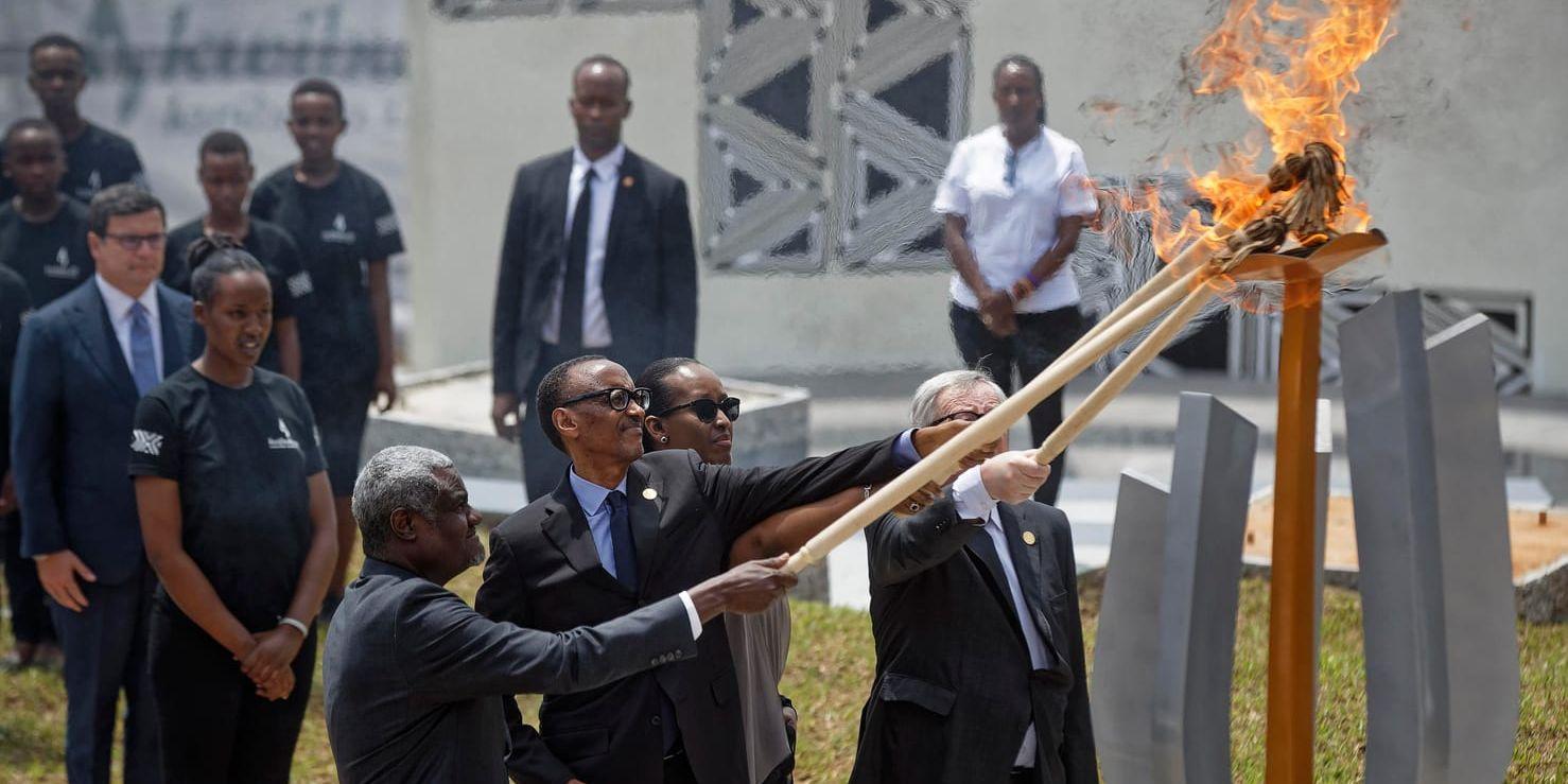Rwandas president Paul Kagame, i mitten, tänder en minneseld i Kigali.