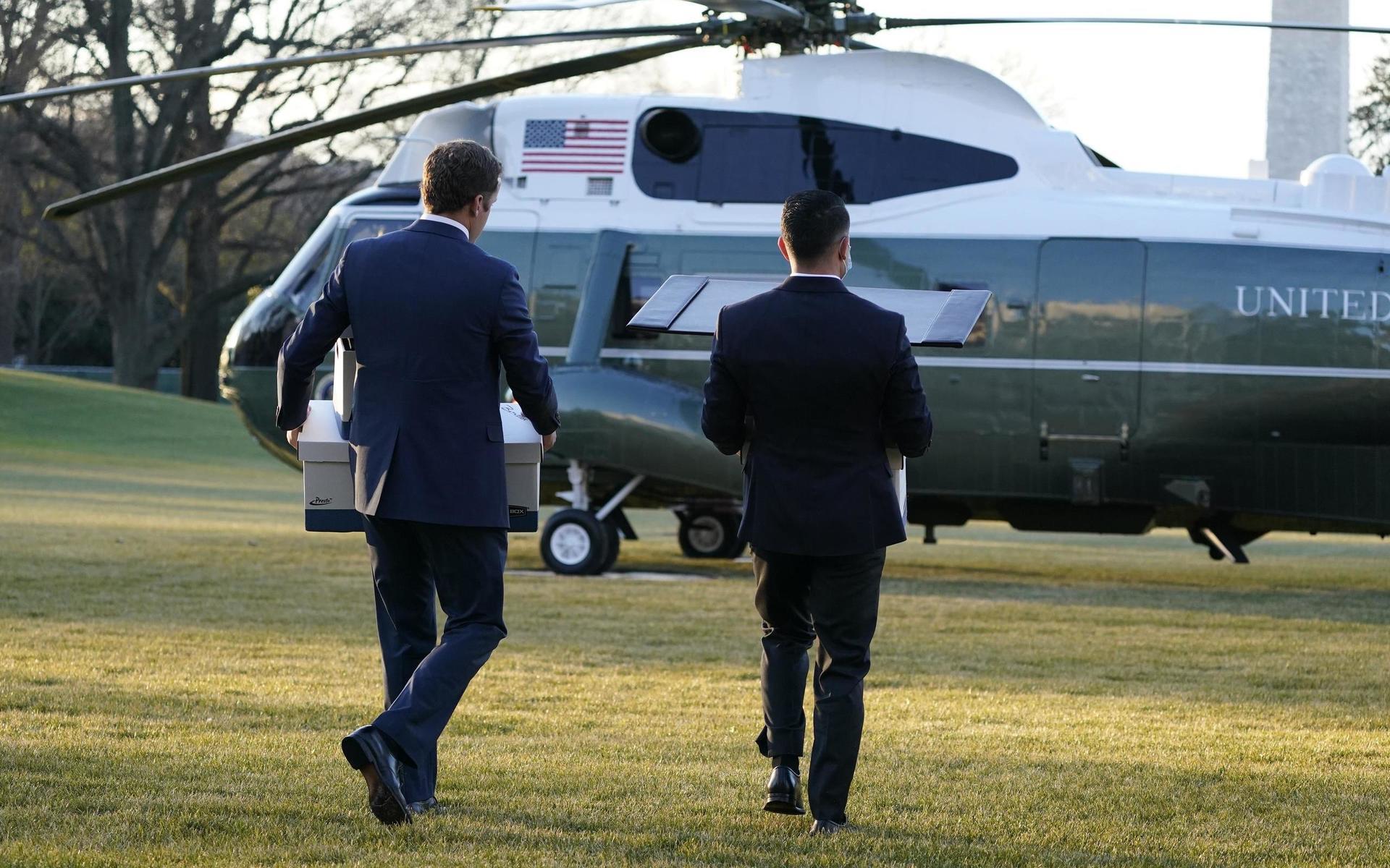 Personal i Vita huset bär ut lådor med dokument innan  Donald Trump lämnar presidentbostaden med helikoptern Marine One.