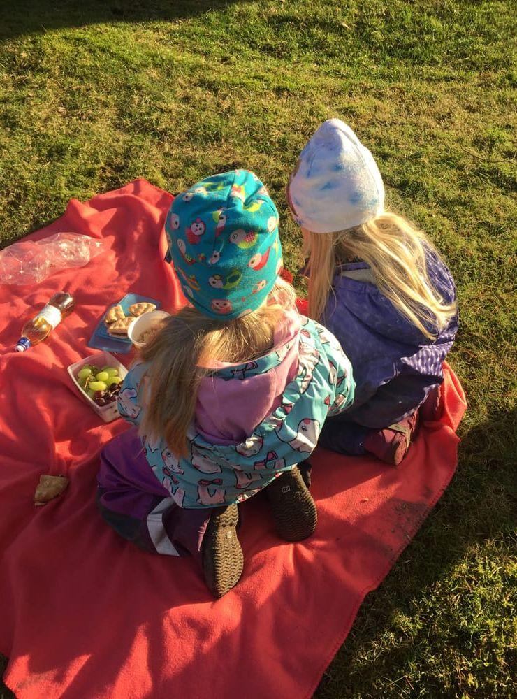 Två goda kompisar som har picknick utomhus. Bilden är inskickad av Therese Hetlelid.