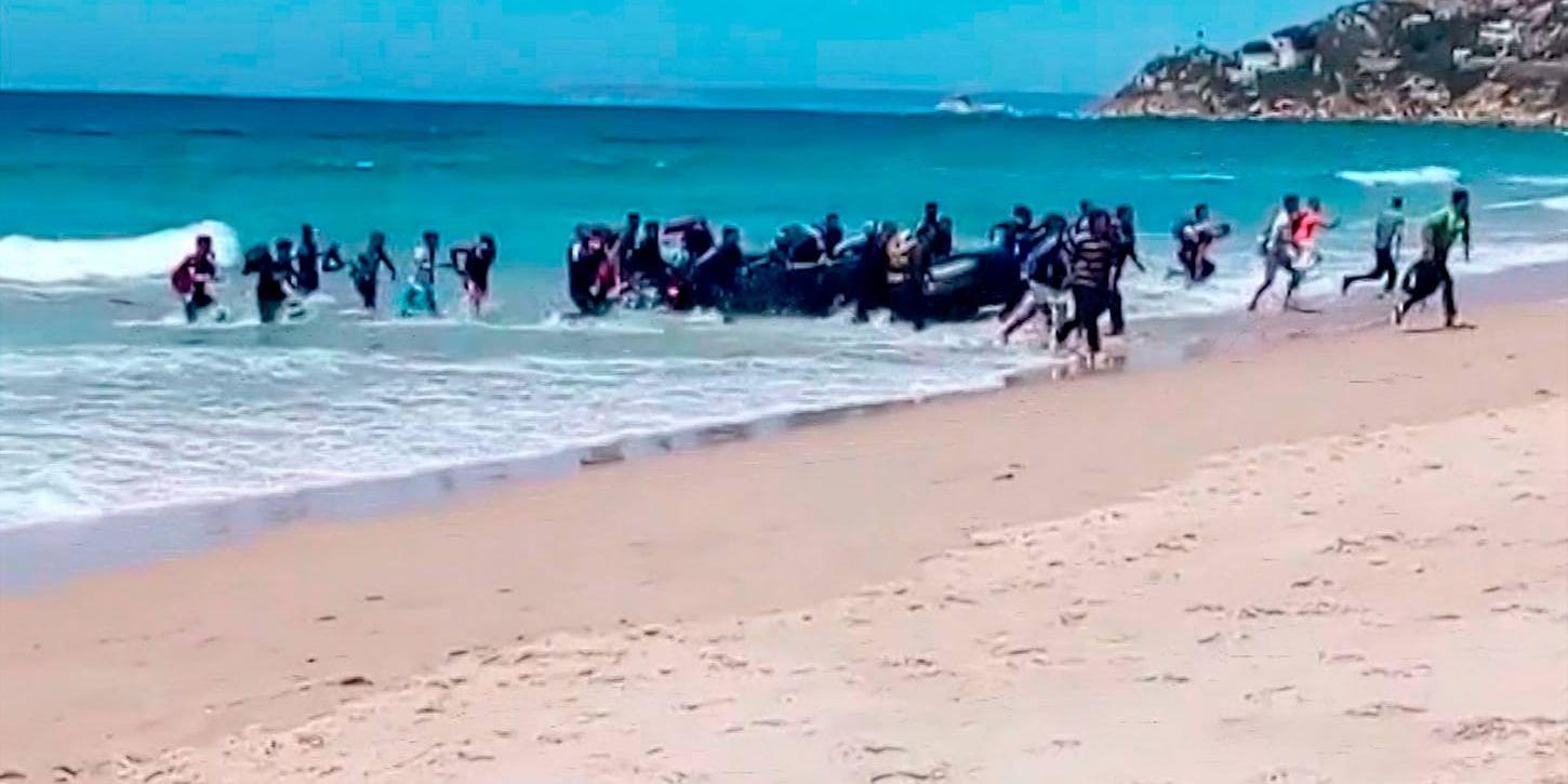 Migranter springer upp längs en strand i Cadiz i södra Spanien i förra veckan efter att ha kommit med en gummibåt över havet. Arkivbild.