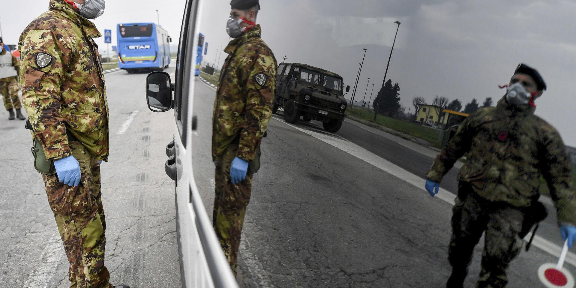 Italienska soldater kontrollerar fordon som vill passera vid de isolerade områdena i norra Italien.
