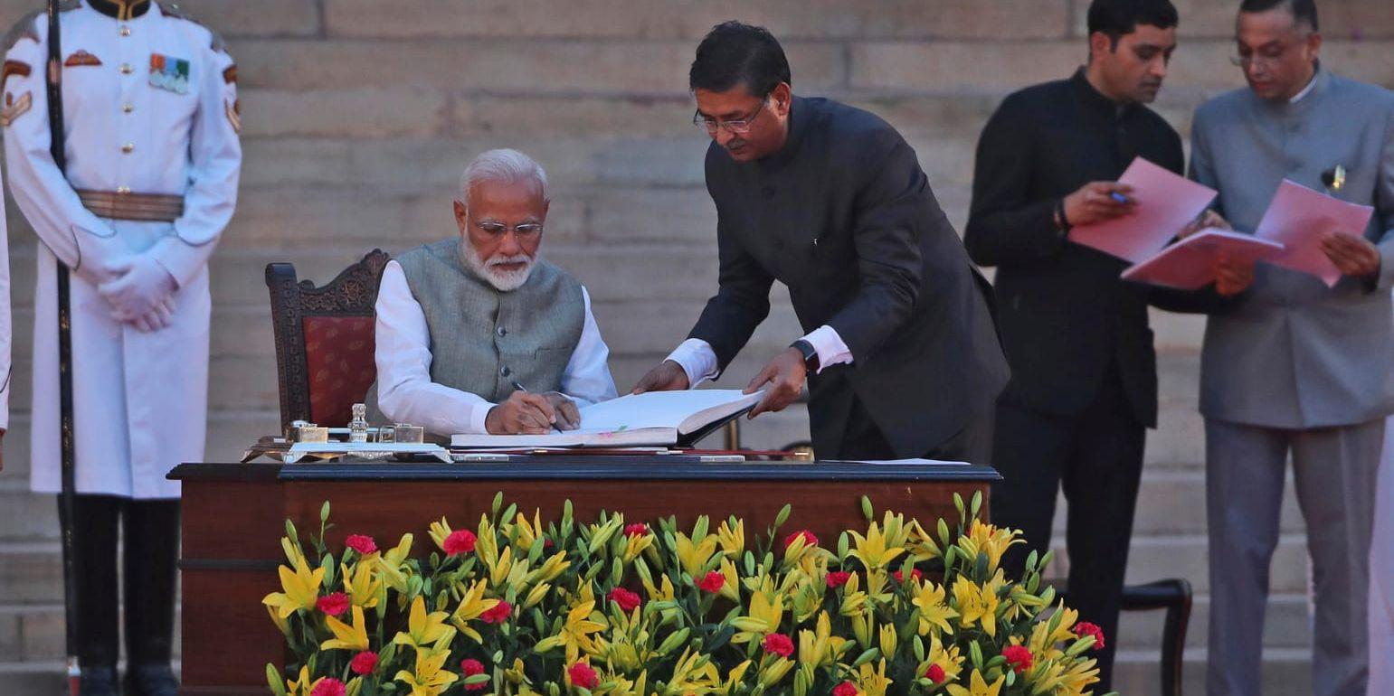Narendra Modi signerar de rätta pappren efter att ha svurit premiärministerns ed.