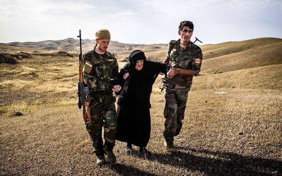 Jesper Söder och en YPG-soldat hjälper en gammal kvinna att fly från IS. Bild: Privat
