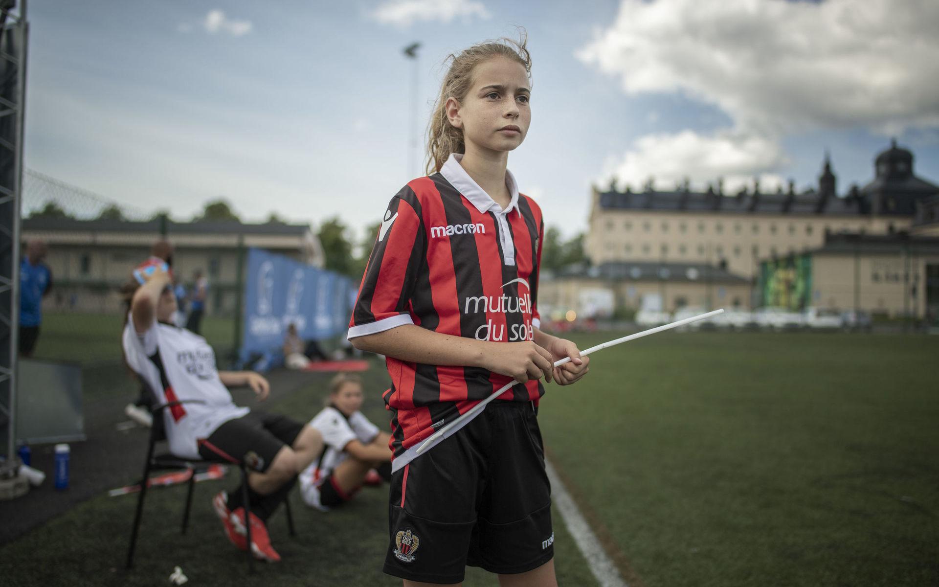 13-åriga Nina Rebel, med den franska flaggan, stöttar laget från sidan.