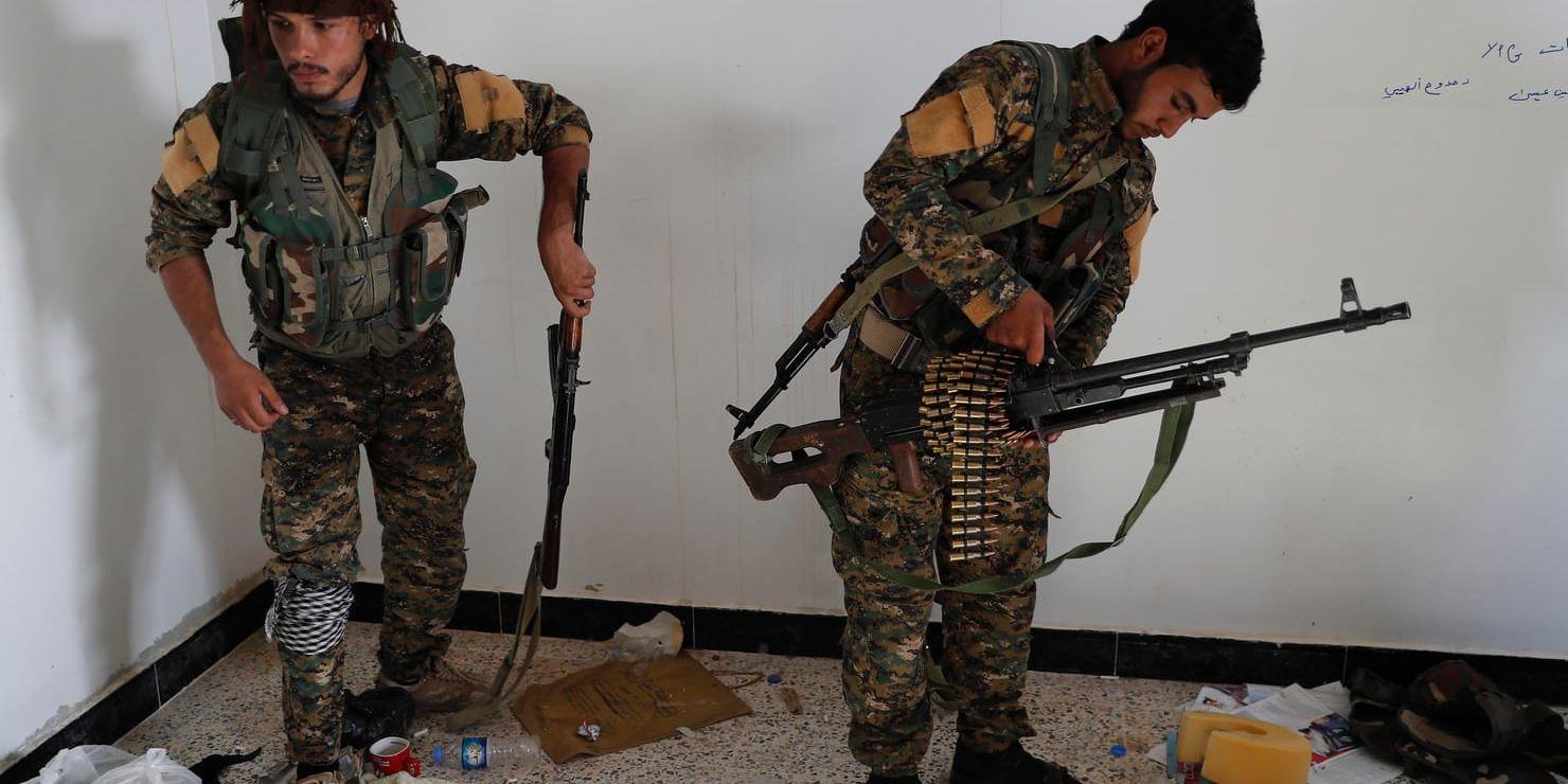 En arabisk (till höger) och en kurdisk medlem i den USA-stödda SDF-milisen förbereder en insats mot terrorrörelsen Islamiska staten. Arkivbild.