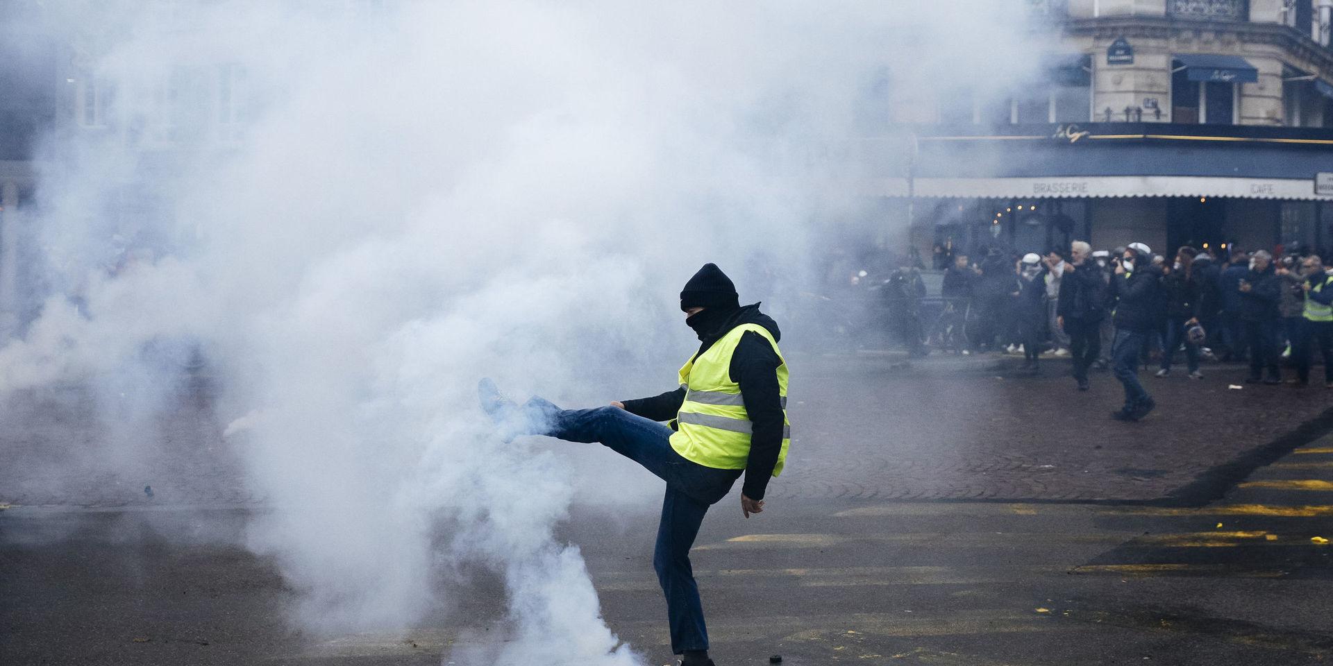 En demonstrant sparkar i väg en tårgaspatron i Paris. 
