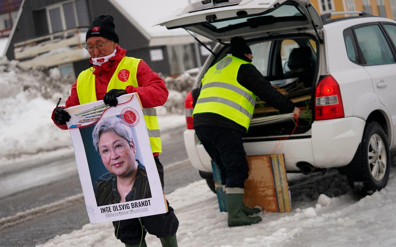 Volontärarbetare för partiet Inuit Ataqatigiit (IA) förbereder kampanjskyltar i Nuuk, Grönland. 5 april, 2021.