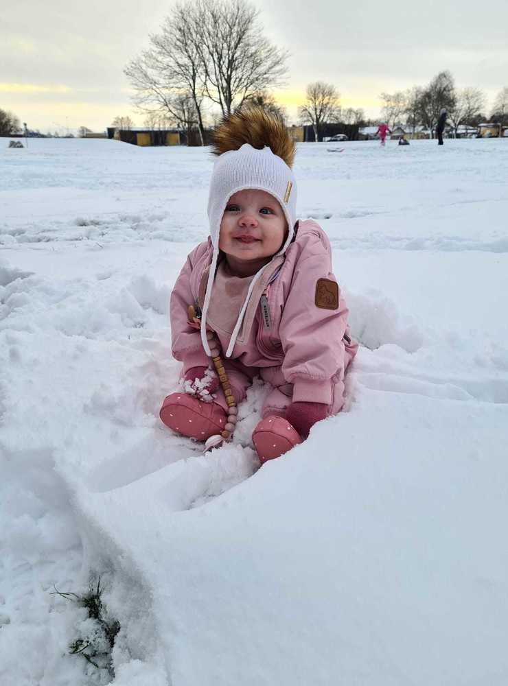 ”Här sitter Elodie 5 månader i livets första snö , och kikar på när storasyskonen åker i backen”, skriver Angelica Wikström. 