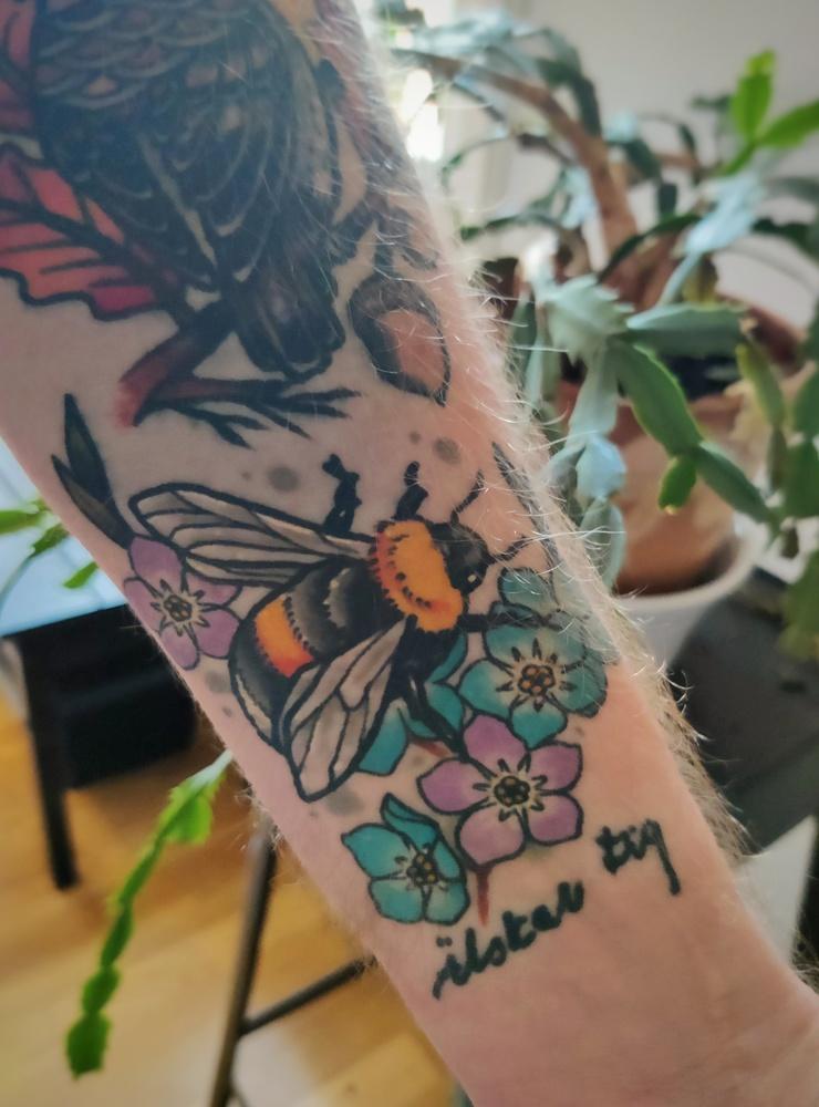 Marcus Pallvid har tatuerat in ett bi och ett par blommor av sorten förgätmigej. Biet för att den ”ständigt arbetar för den stora familjen” och blomman för att det är hans mammas favorit.