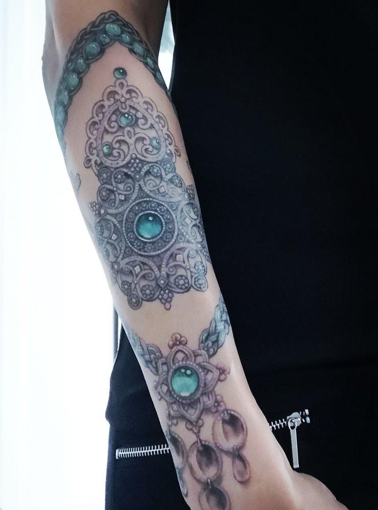 Evelina Söderlund bidrar med sin tatuering på ett samiskt-inspirerat eveighetssmycke.