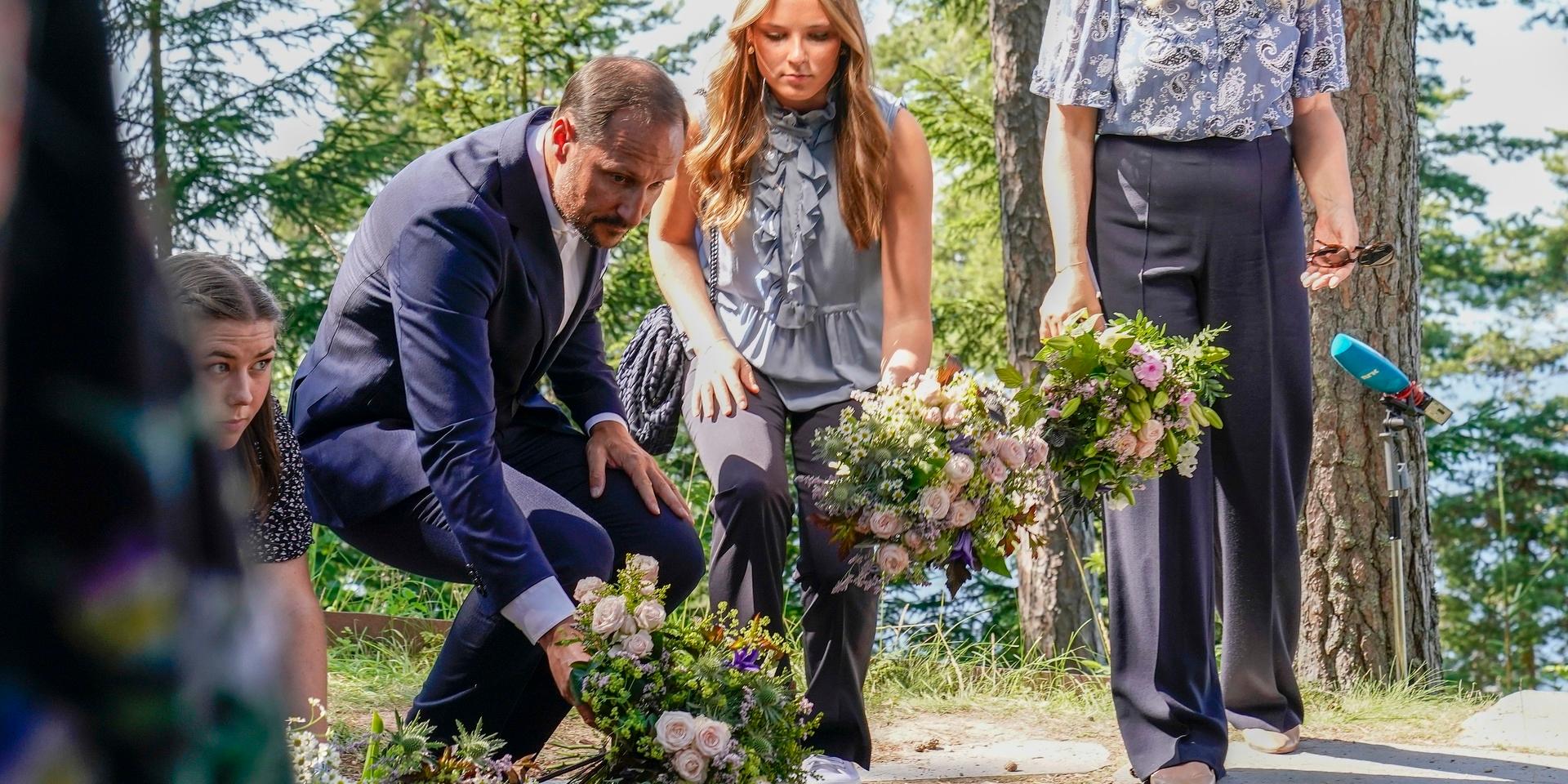 Norges kronprins Haakon och hans dotter, prinsessan Ingrid Alexandra, lägger ner blommor vid 22 juli -minnesmärket på Utøya, på dagen tio år efter terrorangreppet.
