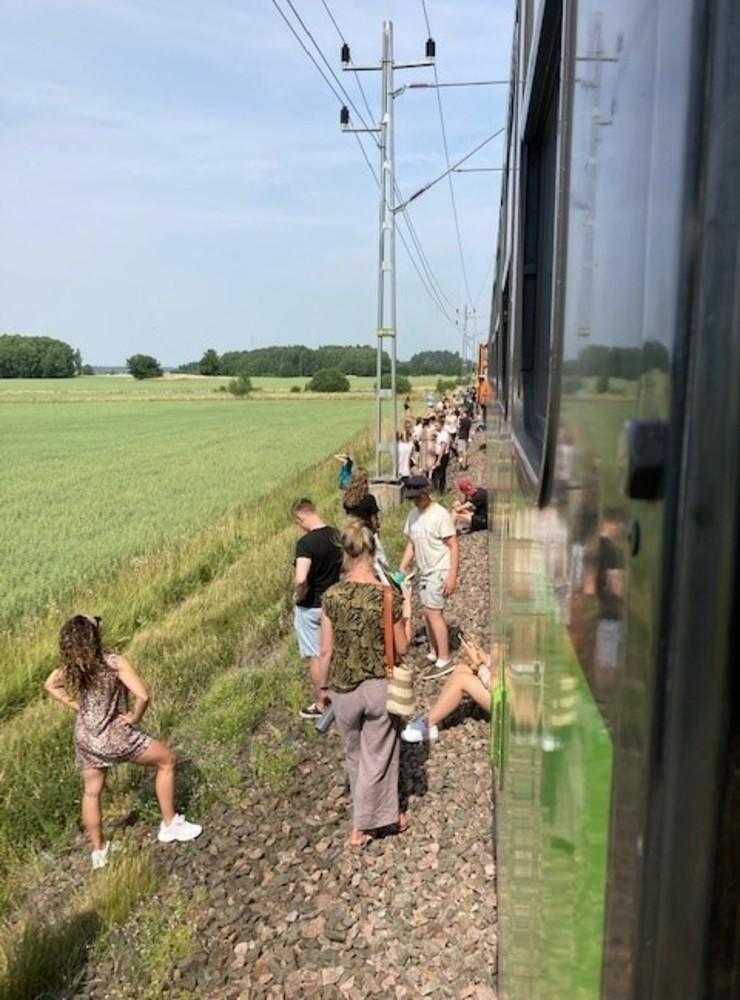 Resenärer har fått kliva av ett av tågen som står still, men enligt en person ombord är det minst lika varmt utanför som på tåget.