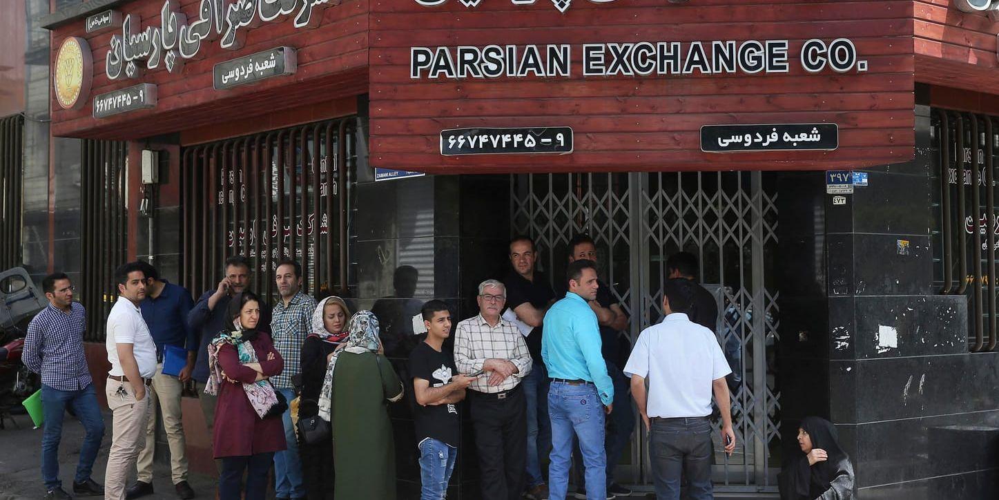 Människor köar utanför ett växlingskontor i Irans huvudstad Teheran. USA:s sanktioner har slagit hårt mot landets ekonomi.